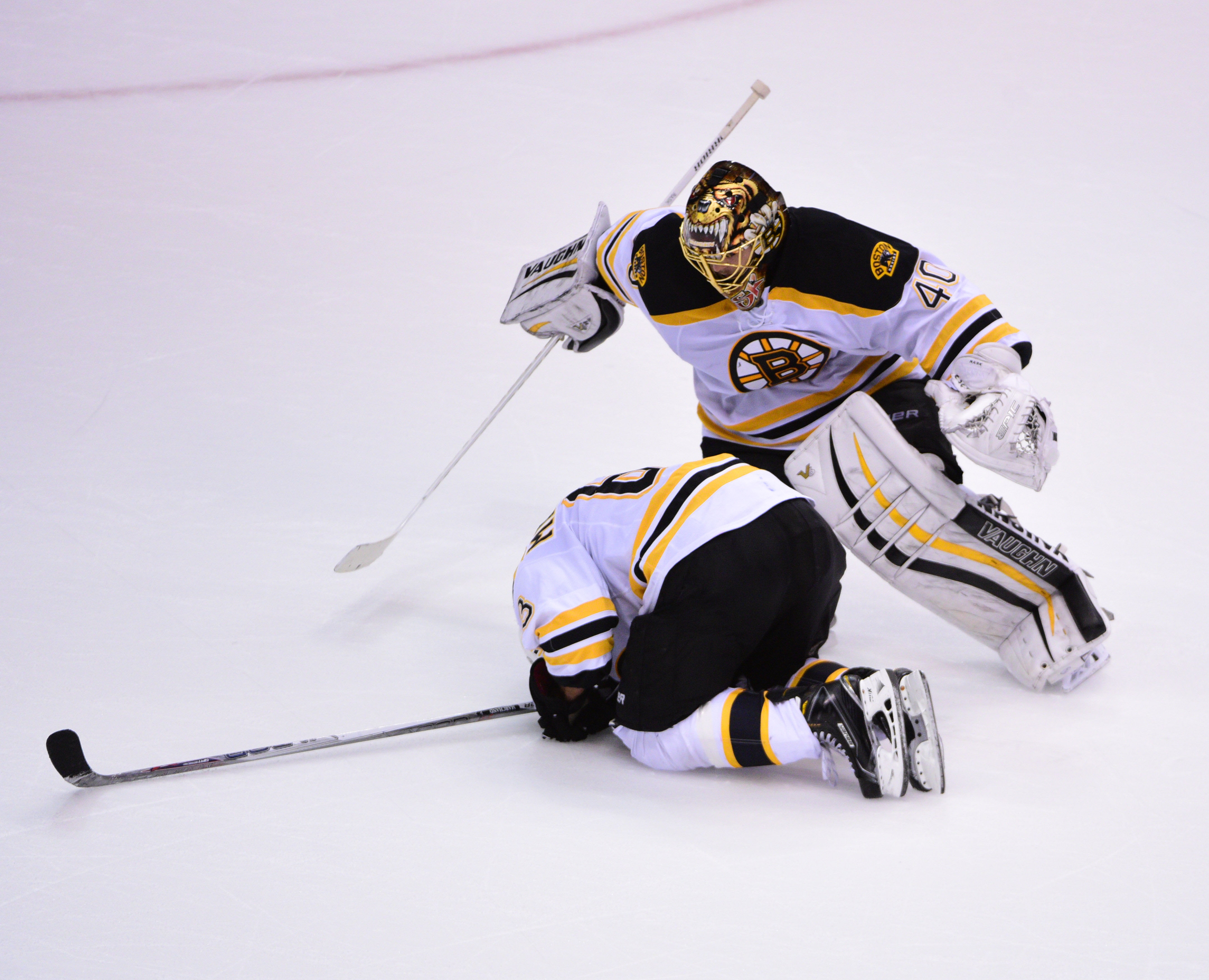 Bruins goaltender Tuukka Rask checks on forward Brad Marchand after he went down late in the third period Saturday.