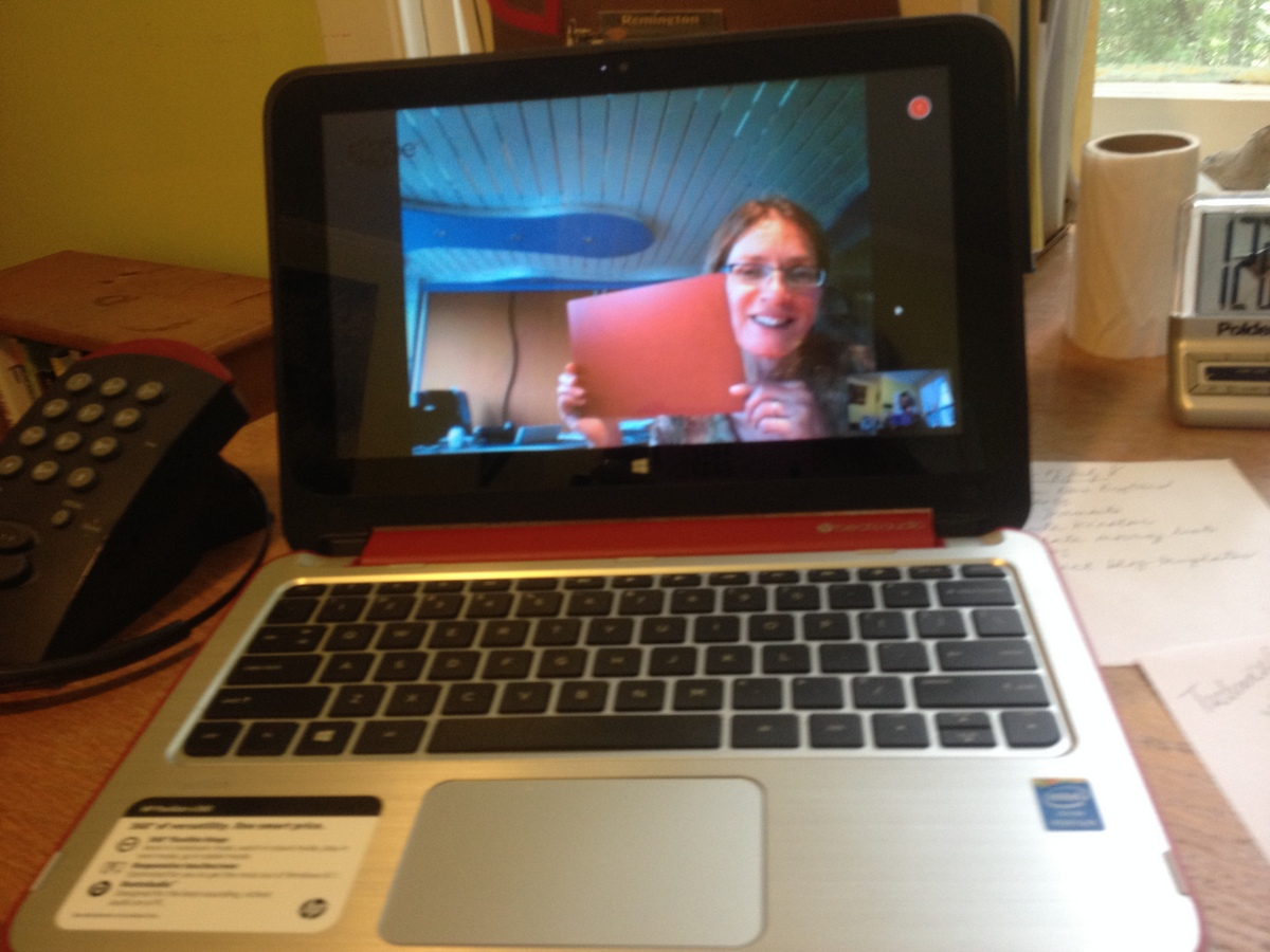 Lina at Piet's showroom holding up choices of countertops via Skype.