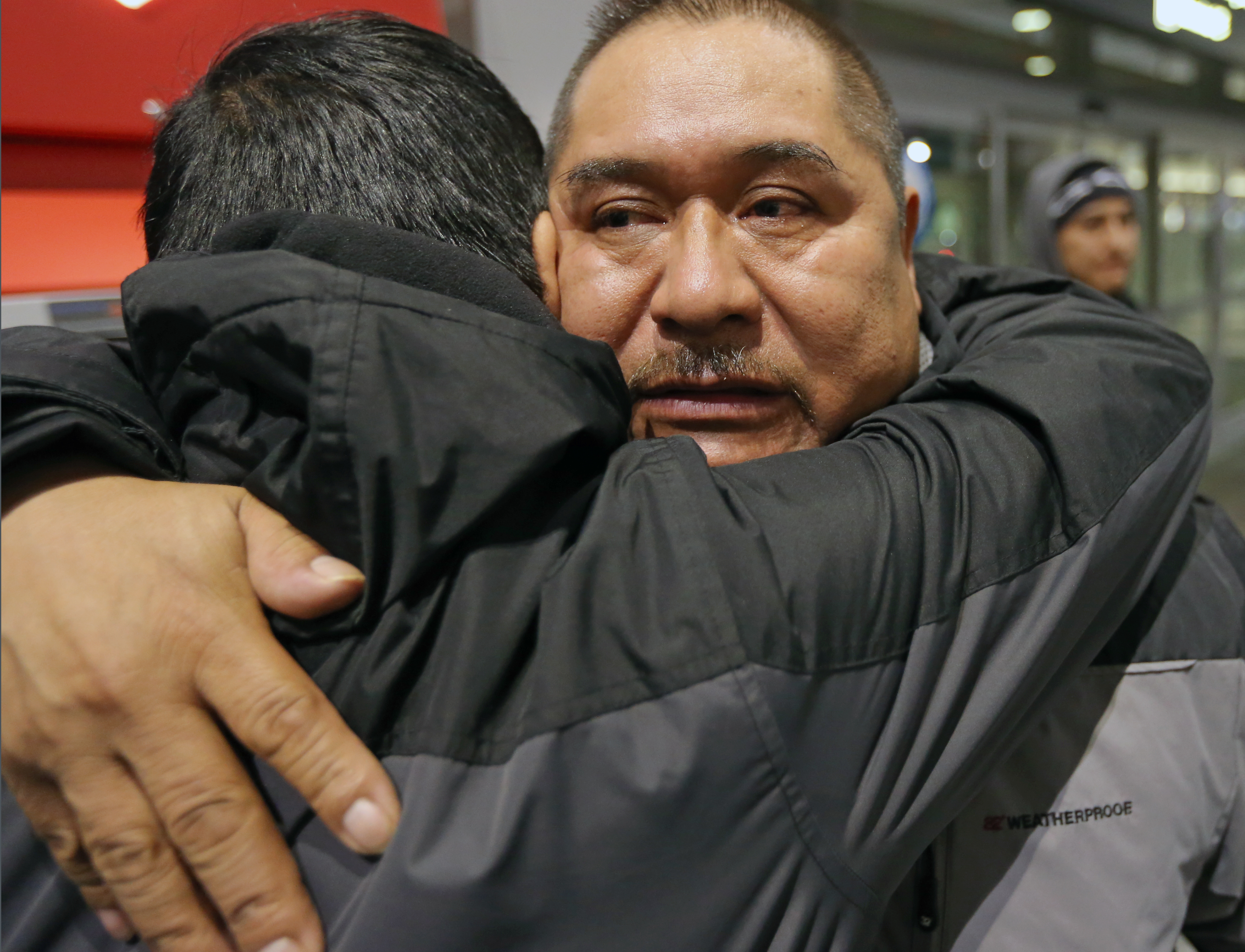At Logan airport, Terminal A for a 5:45 am flight, Isidro Macario gives his son Isidro Jr, a hug goodbye.