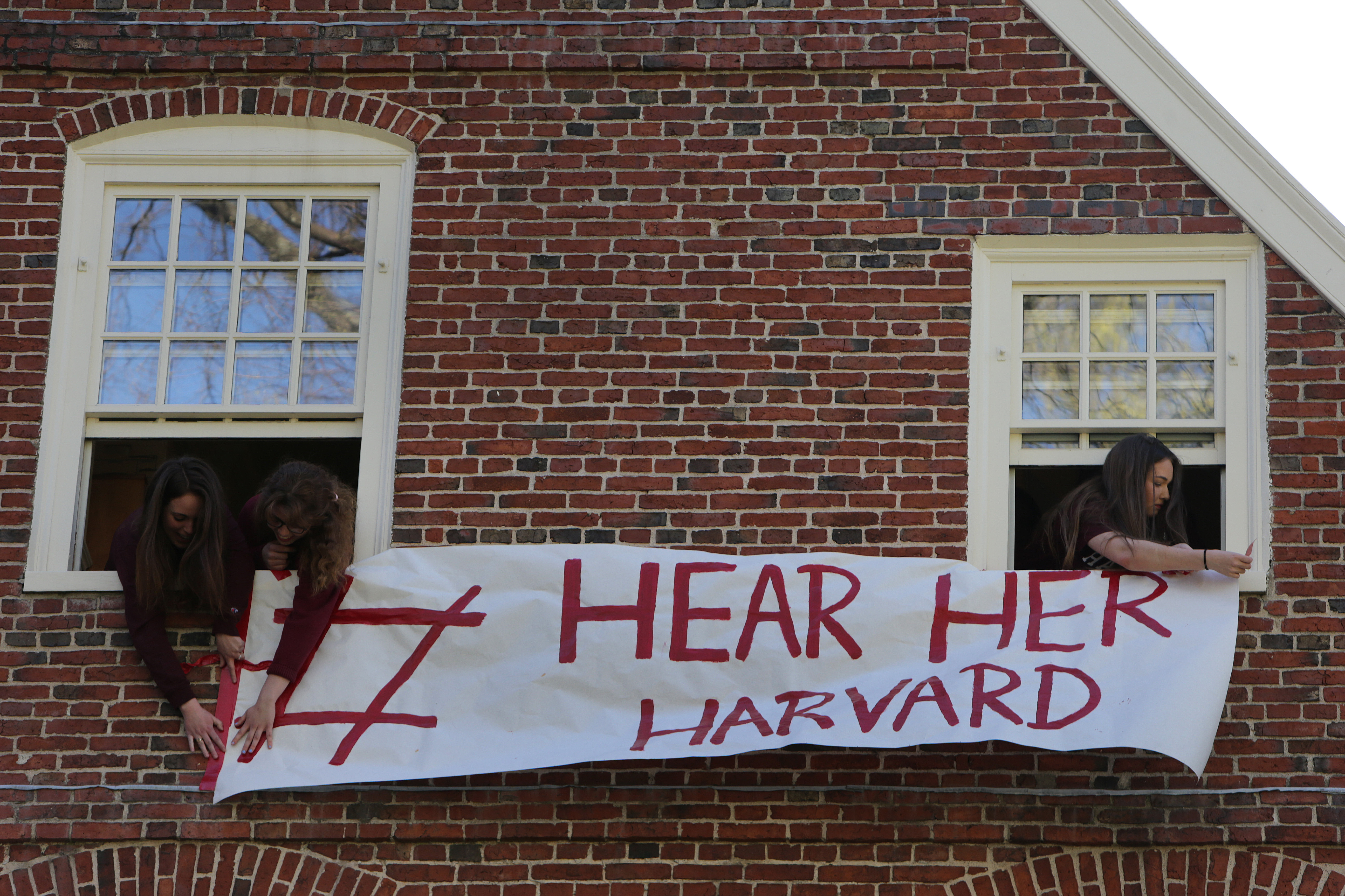 Demonstrators hung a banner outside Massachusetts Hall before the rally and march.
