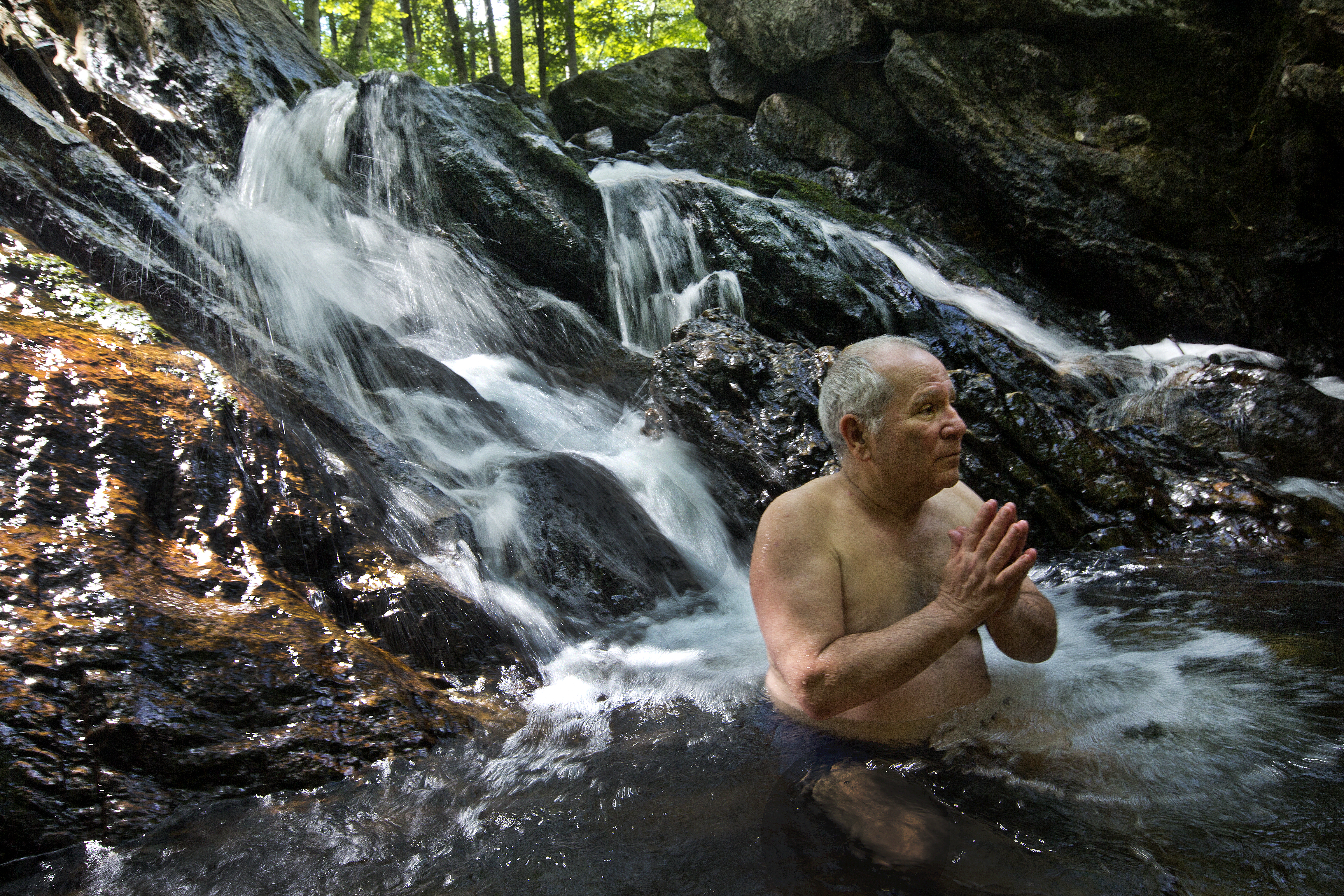 Jimmy LeSage, founder of the New Life Hiking Spa, relaxes in the Kent Pond waterfall.