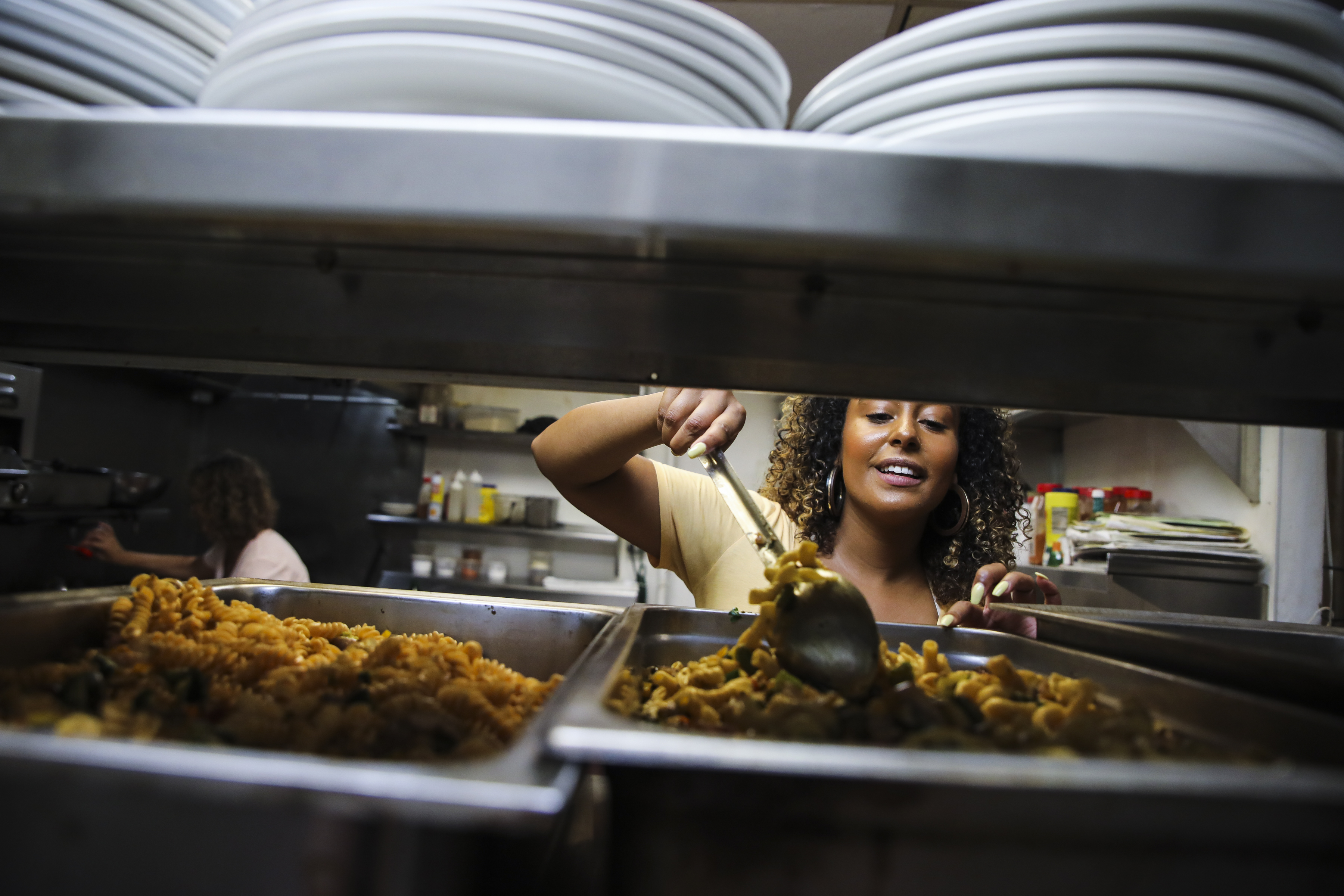 Celsea Tibbitt stirred a tray of pasta primavera as she prepared the meals to be delivered to people along Methadone Mile.