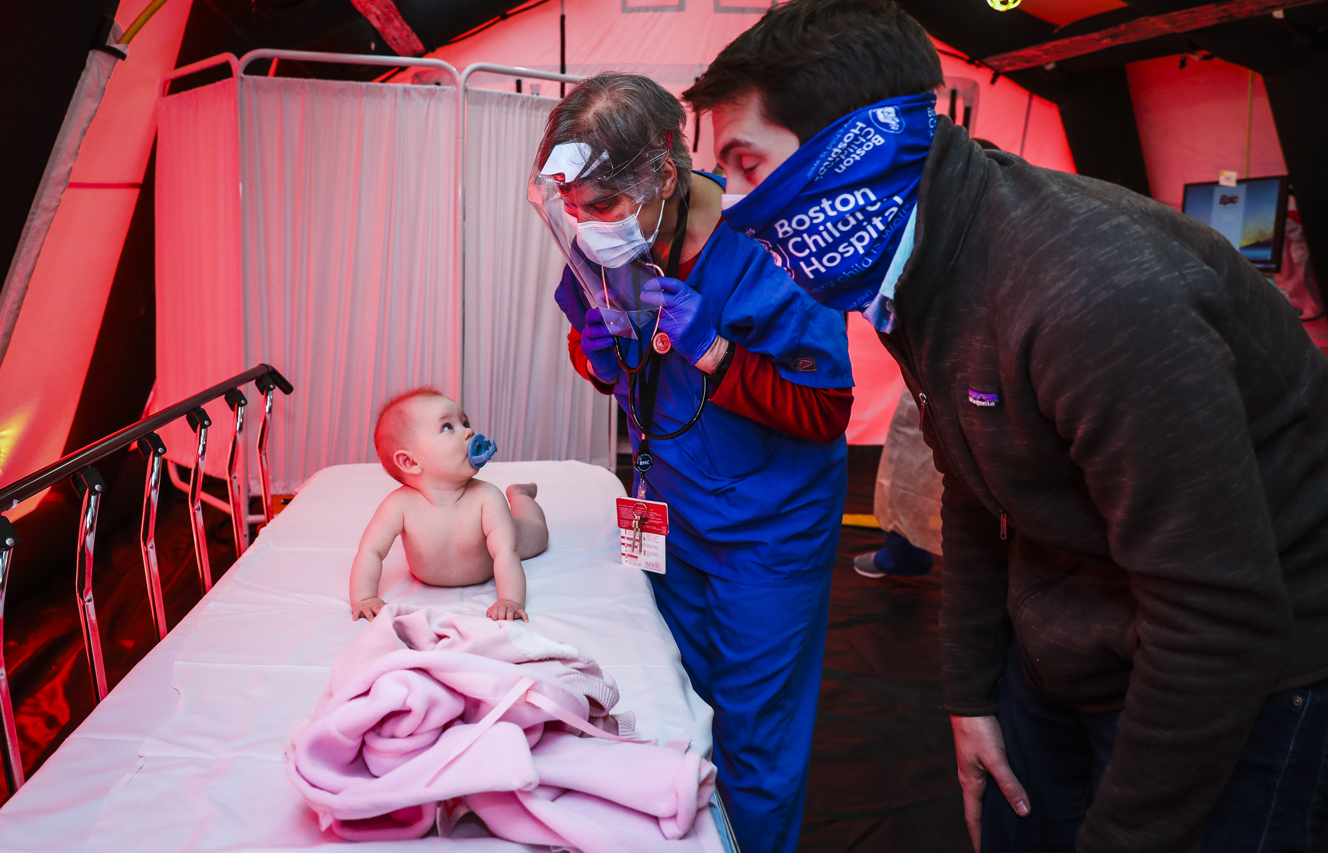 Boston Medical Center pediatrician Dr. Randa Reitman performed a checkup on 8-month-old Bennett Gill while her father Brian provided her comfort in a pediatrics tent set up outside of Boston Medical Center.