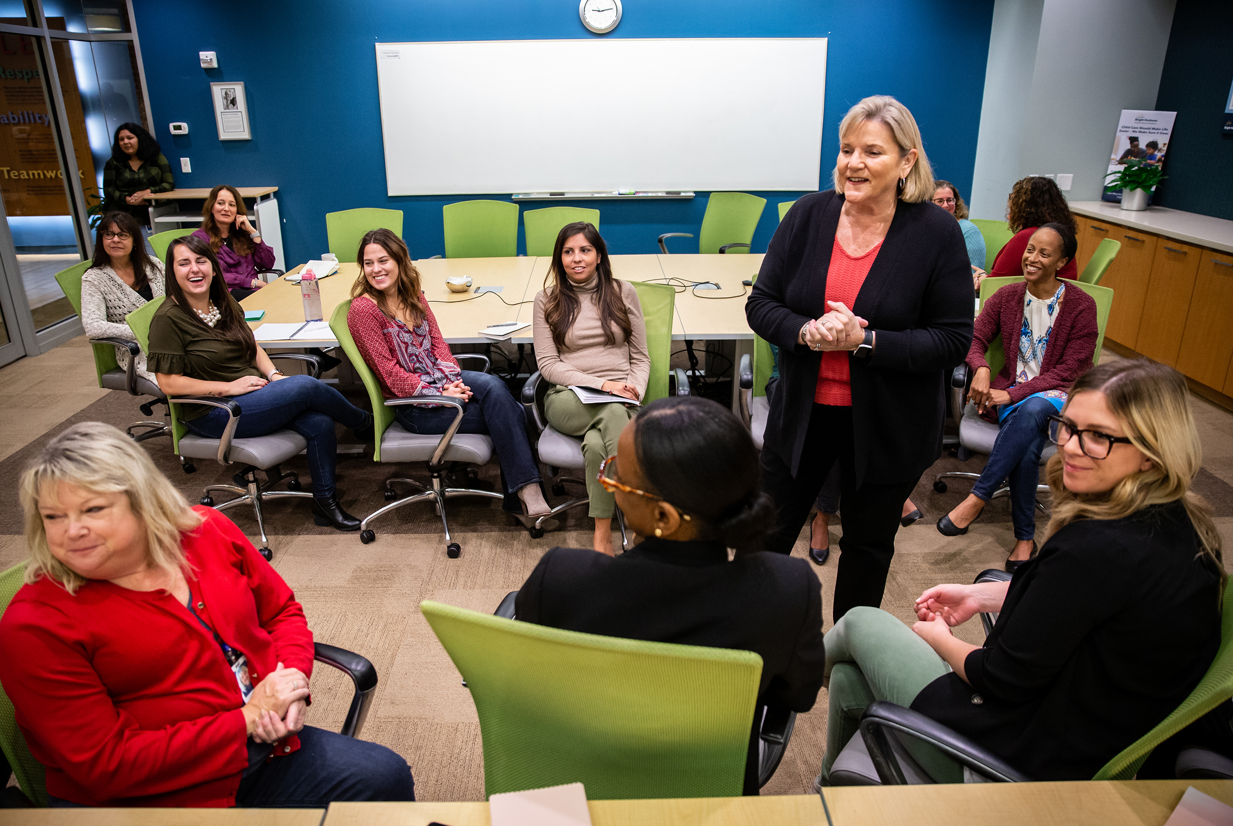 Maribeth Bearfield (standing), chief human resources officer at Bright Horizons, leading a staff meeting.
