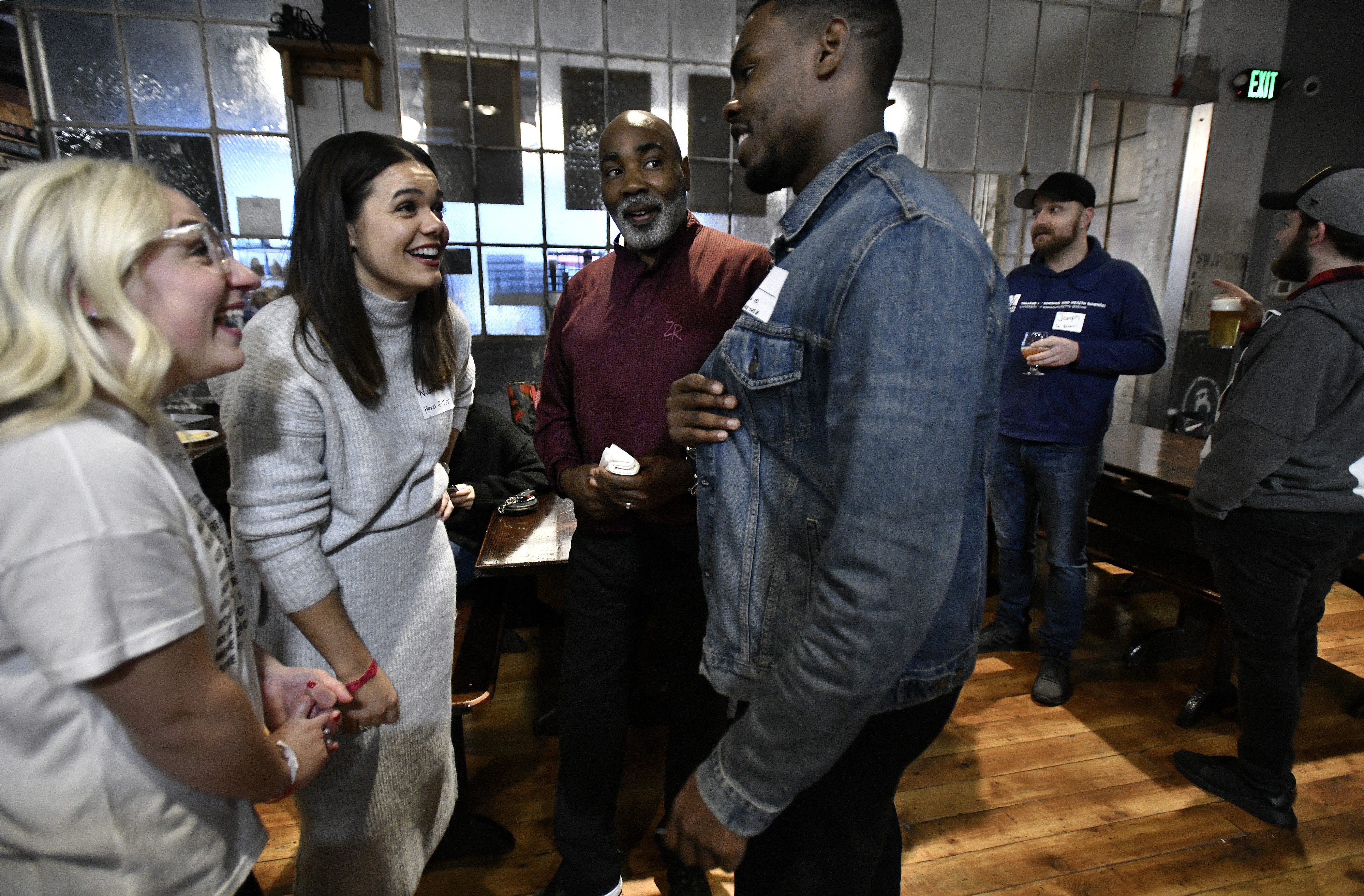 From left, organizers Claire Wickersham, 28, and Natalie Shellito, 29, talked with off-duty Boston police Officer Frank Williams, 57, and C.J. Louis, 24, at Dorchester Brewing Co. “People have a negative view toward aging,” Wickersham said, “and that’s got to change.”