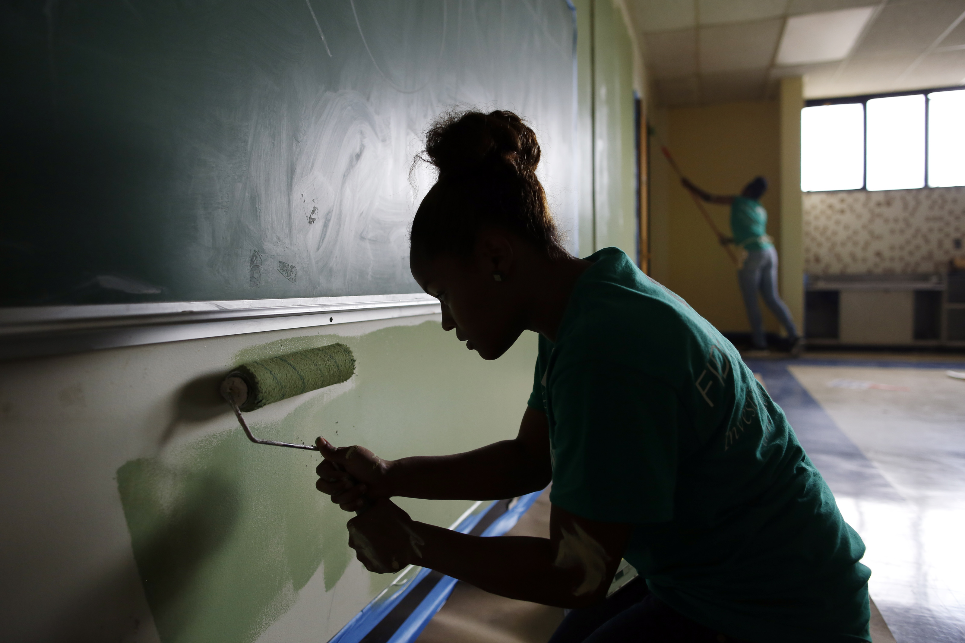 Fidelity employees Eva Sanchez (foreground) and Iman Cohen-Whitaker helped spruce up the former Marshall Elementary School in Dorchester on Thursday.