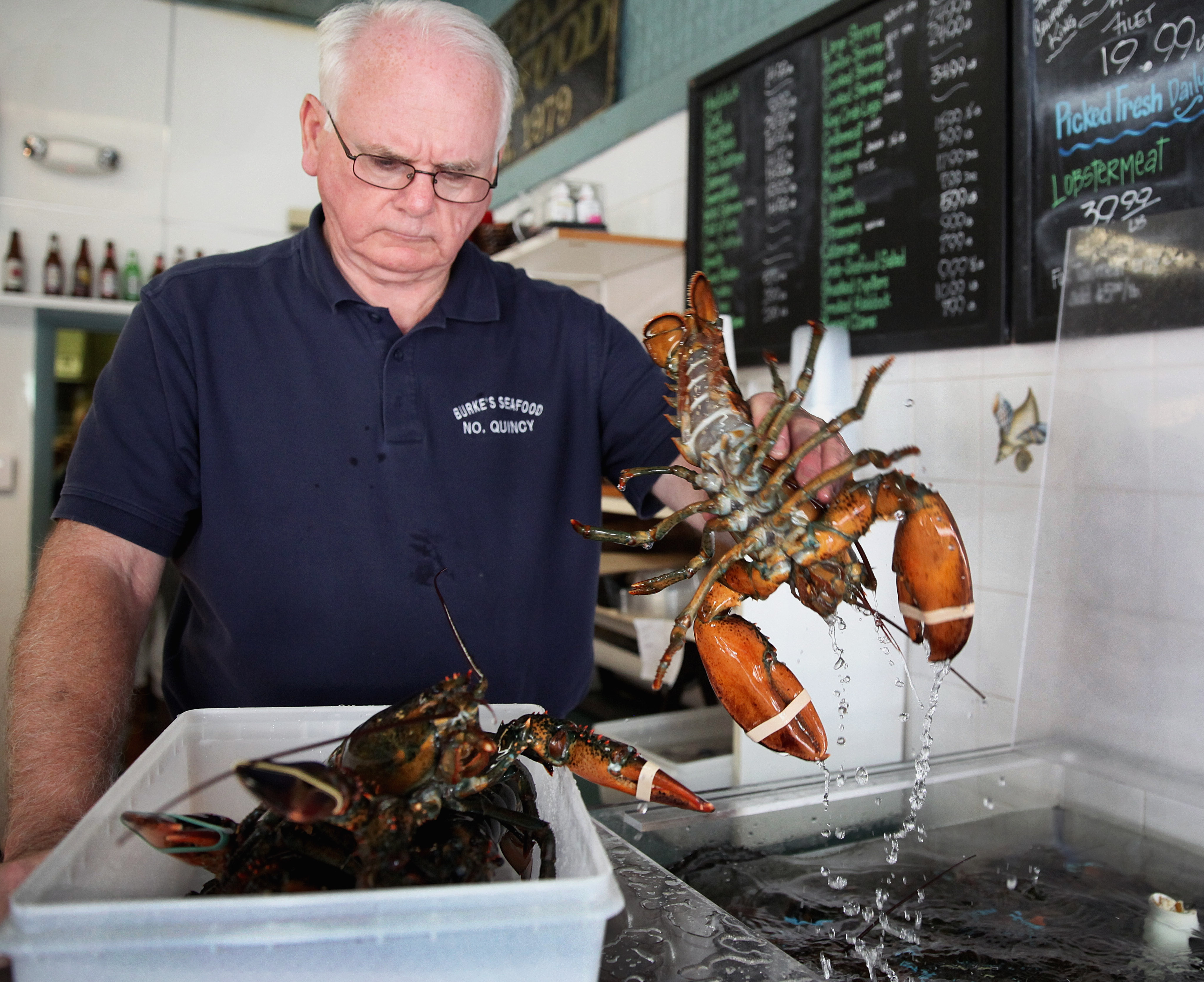 Dick Burke set aside lobsters for a phone order at Burke’s Seafood in Quincy, where prices are down from as much as $12 a pound earlier this year.