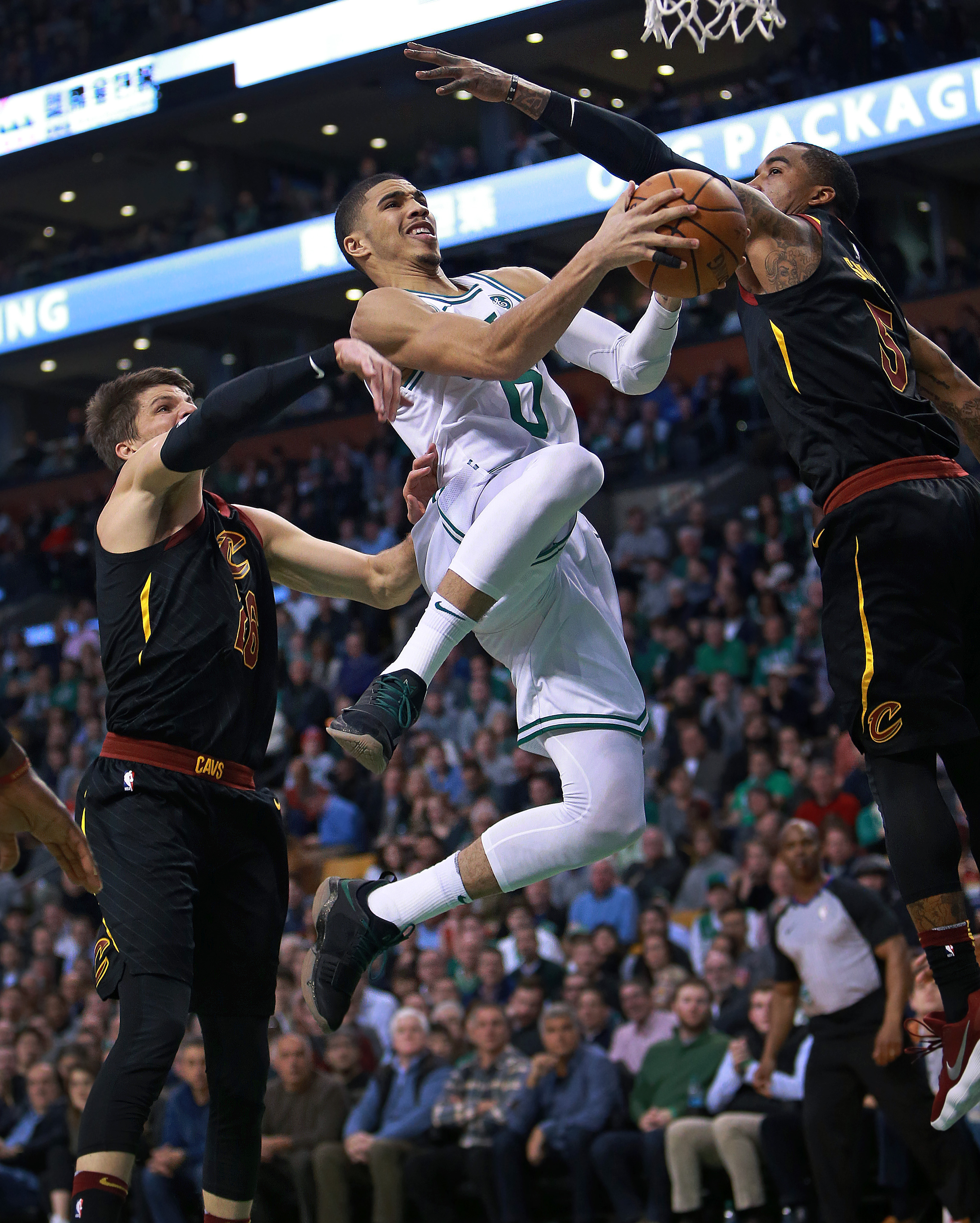 The Celtics’ Jayson Tatum split the defense of Kyle Korver (left) and J.R. Smith for 2 points in the first half.