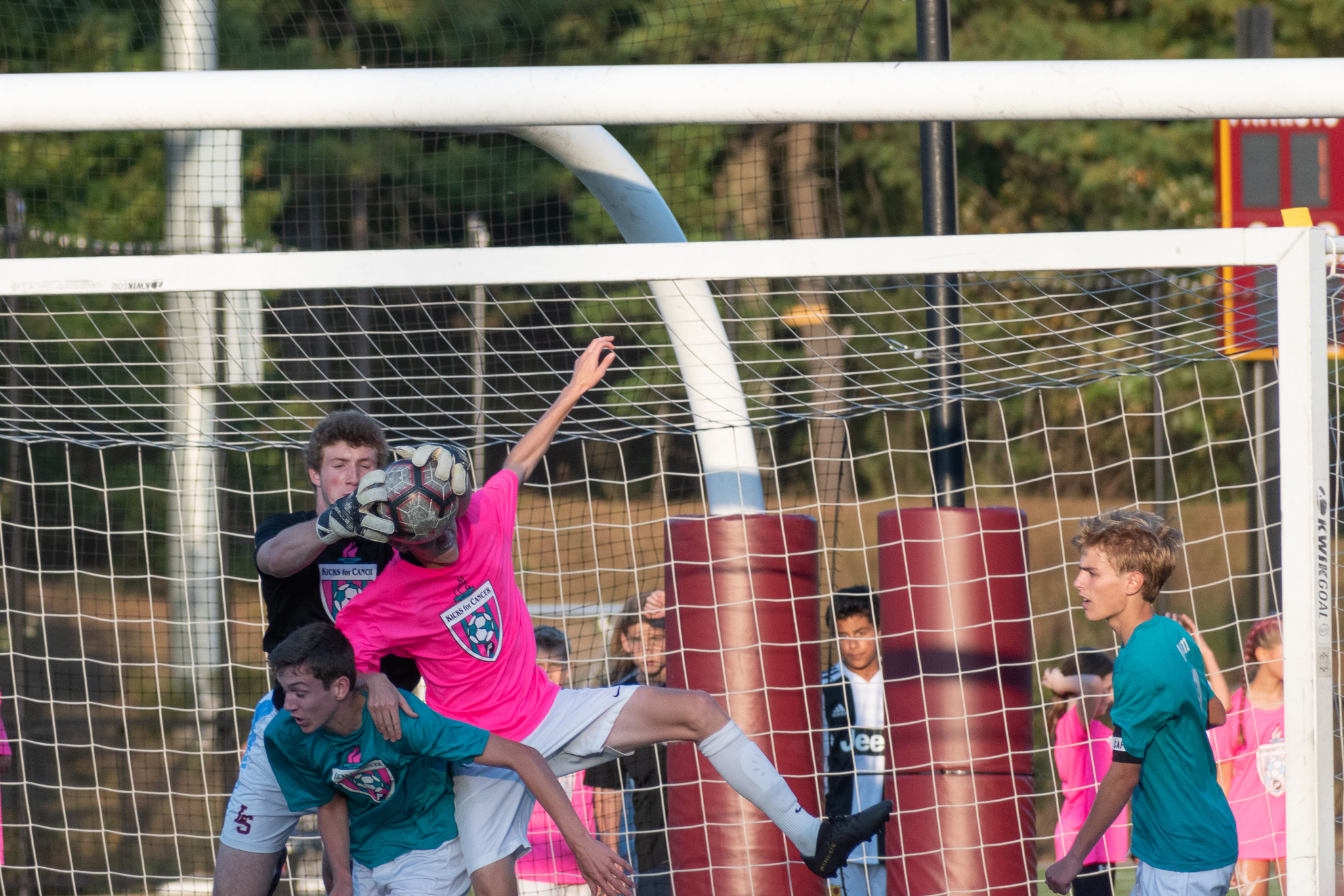 Lincoln-Sudbury goalkeeper Wilson Sneath traps the ball while a C-C forward tries to head it.