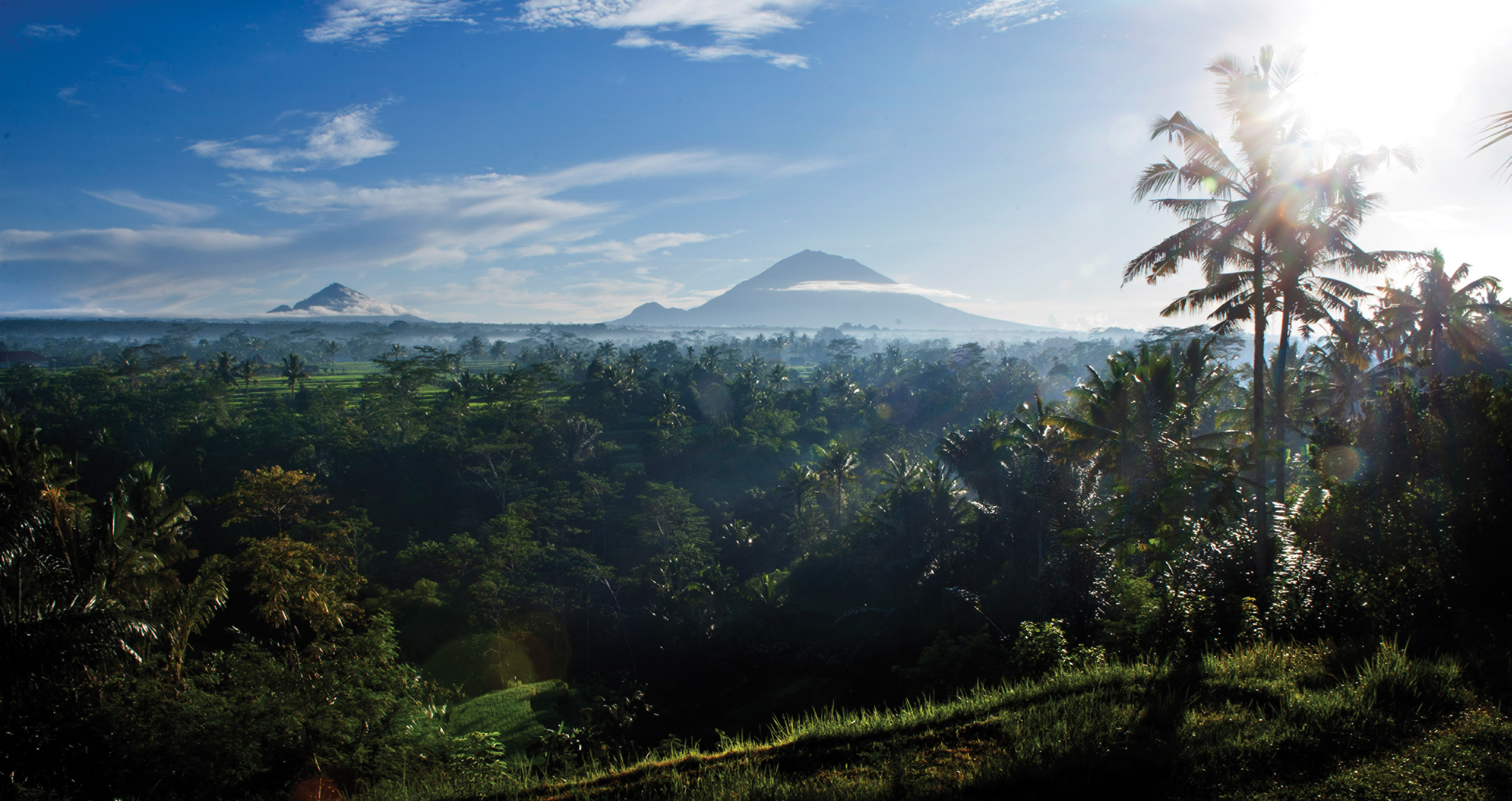 Mount Agung (on right) and Mount Batur rise in the distance.