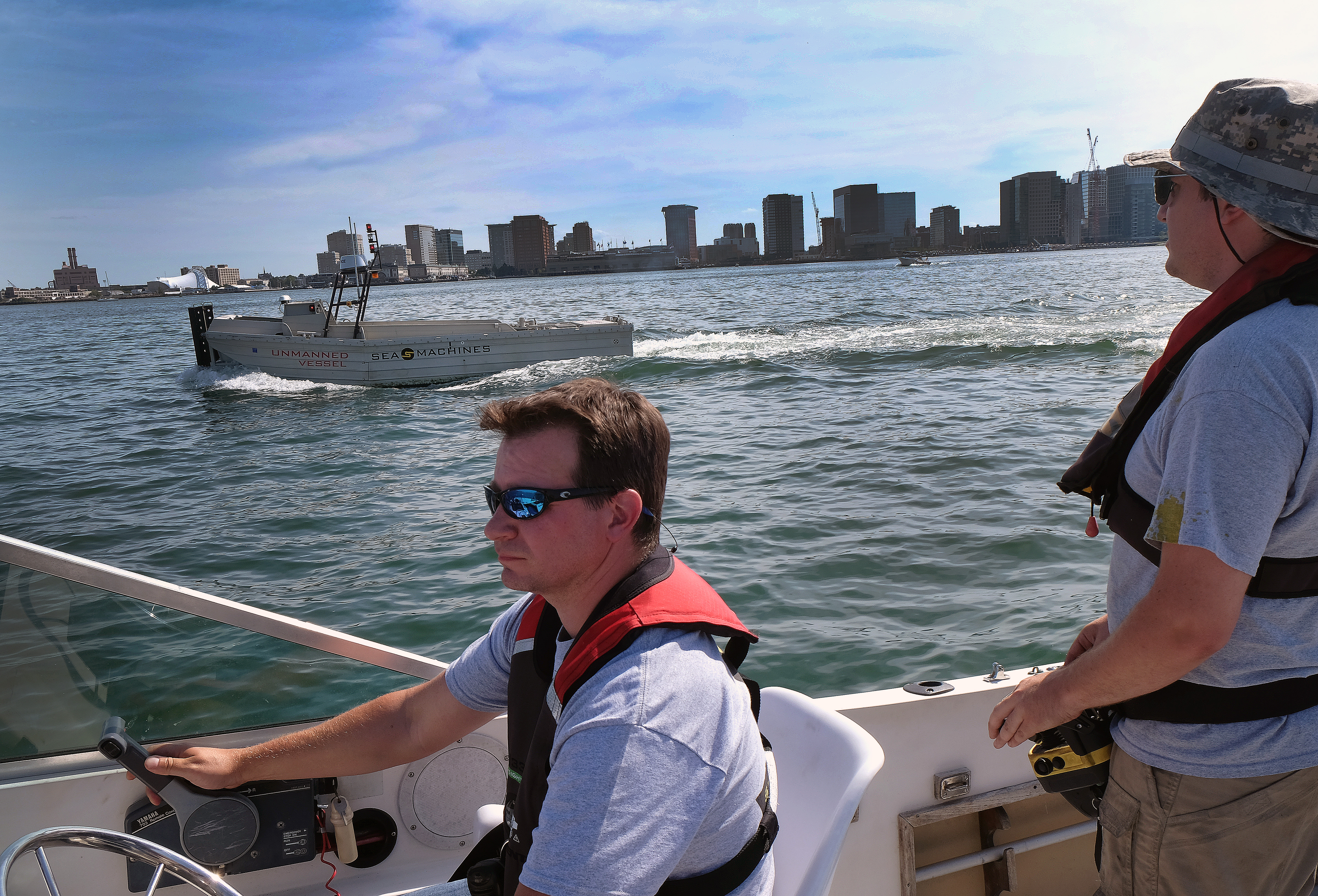 Jeff Bartkowski of Sea Machines took the helm of a chase boat while a colleague controlled one of the company’s unmanned vessels during a test run in Boston Harbor.