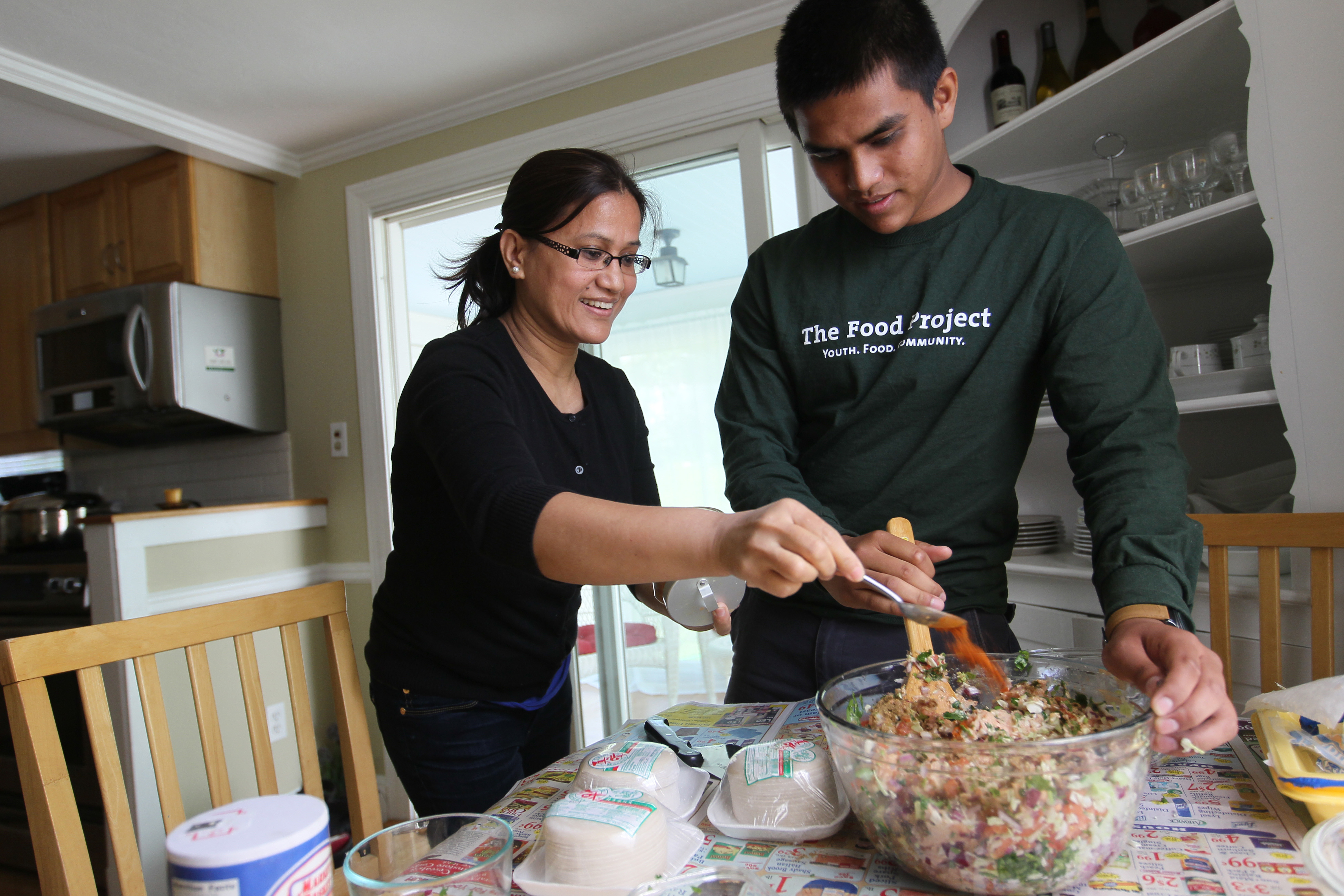 Gaurav Dangol mixes ground chicken filling, while his mom, Krishna Maharjan, adds spices to make momos, meat and vegetable dumplings from Nepal.