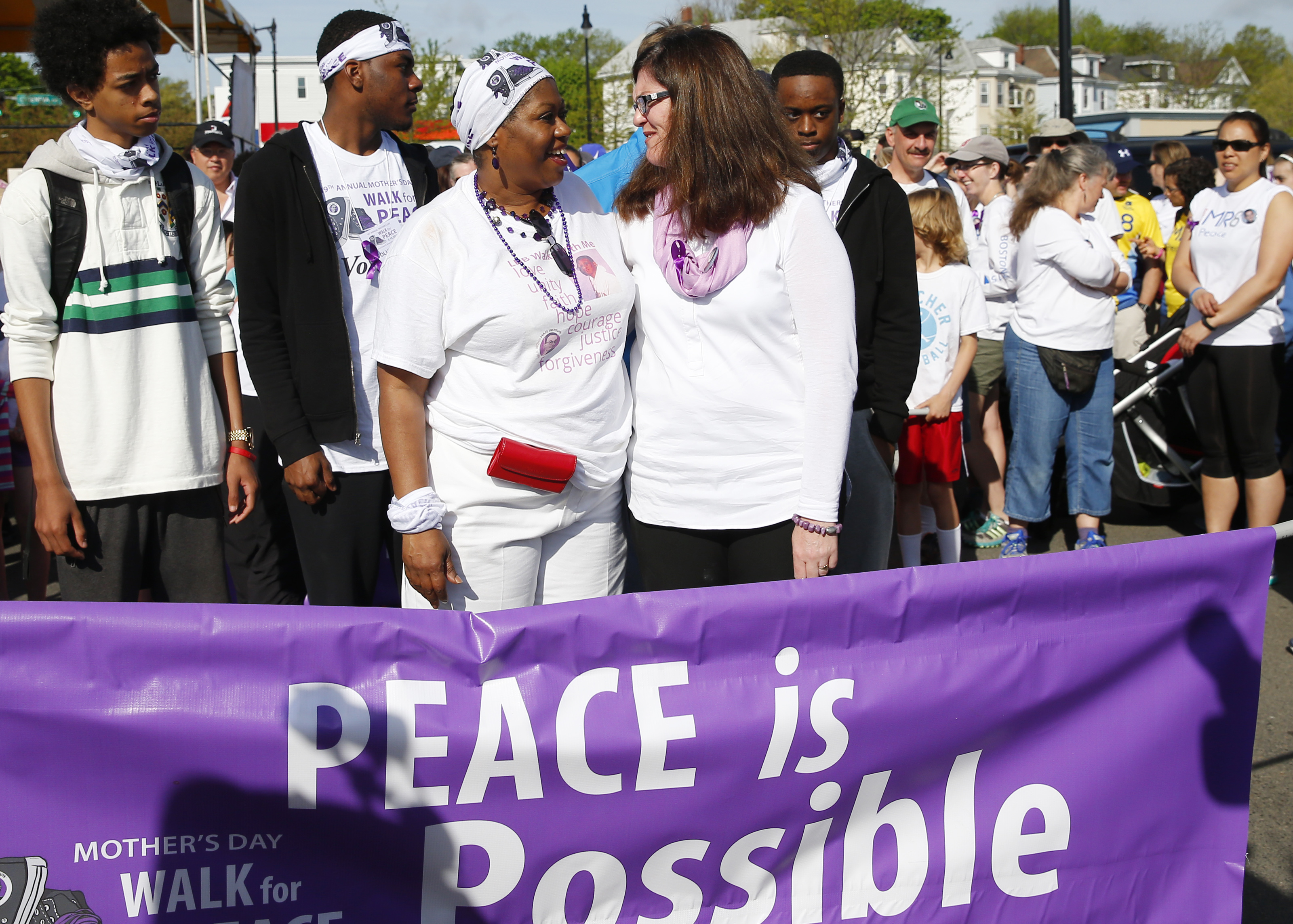 Tina Chery (left) hugged Denise Richard during the Mother’s Day walk for Peace in Dorchester on Sunday.