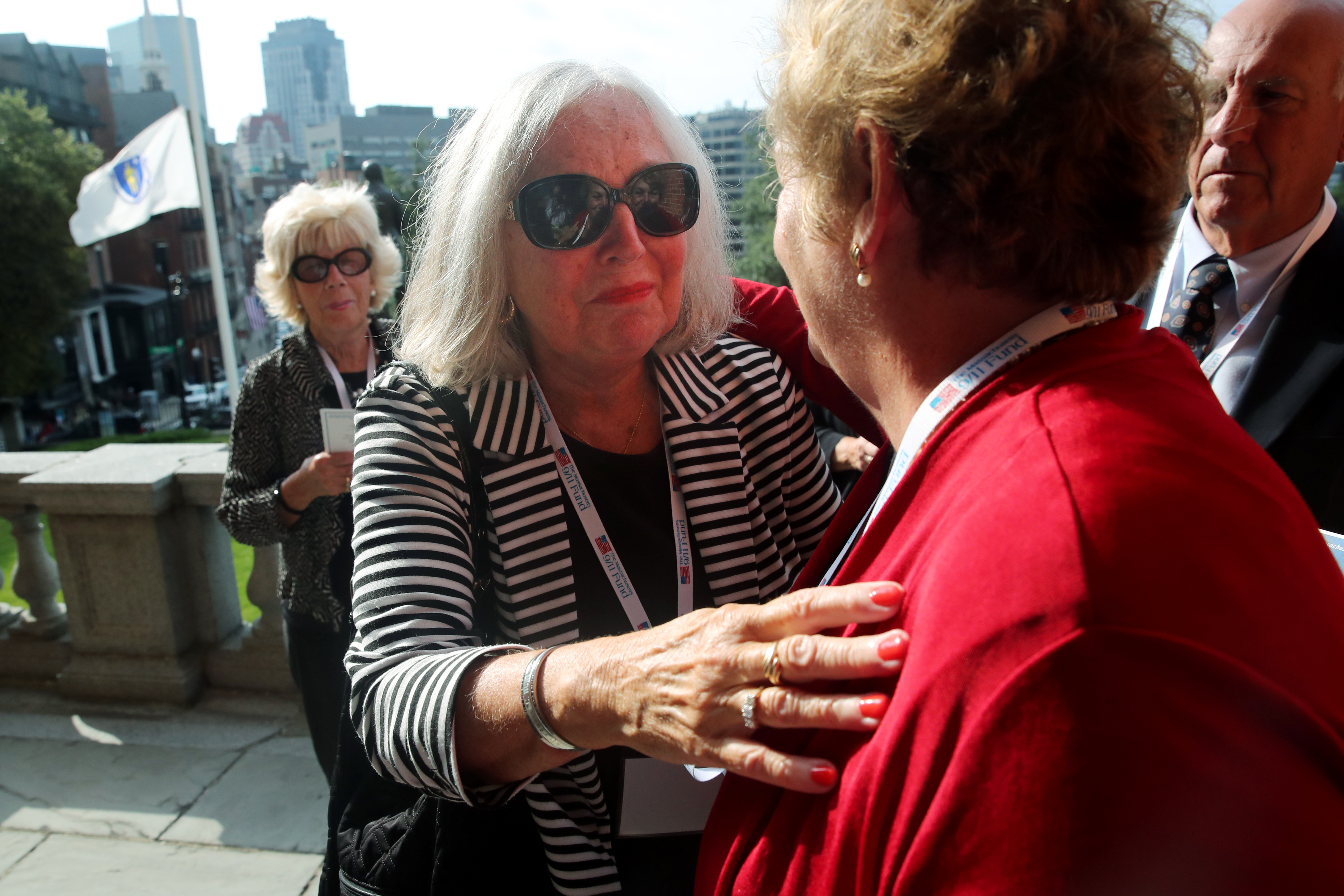 Dian Hunt embraced Mary Ferron during the Flag Lowering Ceremony and Reading of Names.
