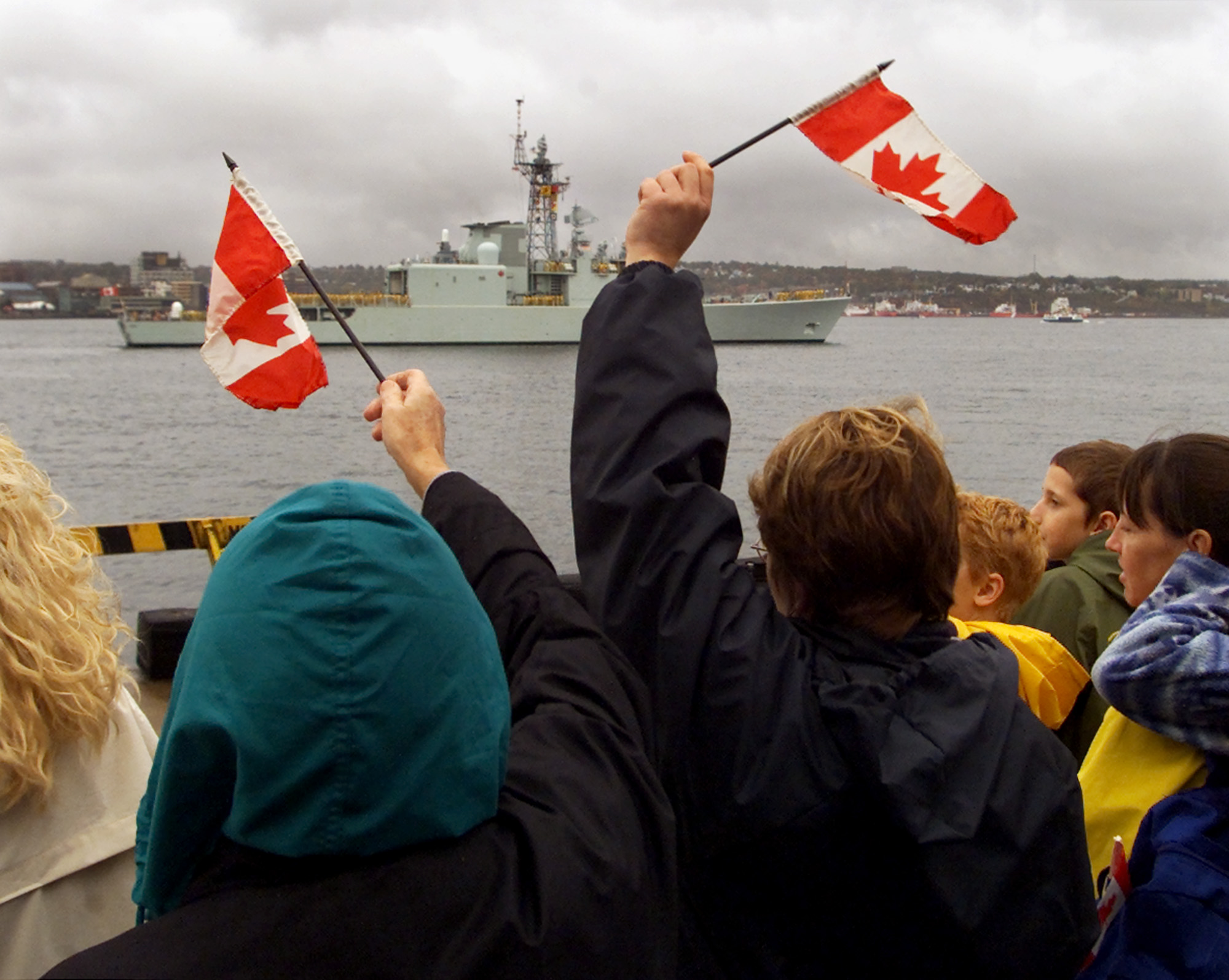 Family members wave as the HMCS Iroquois heads out of Halifax to the Persian Gulf.