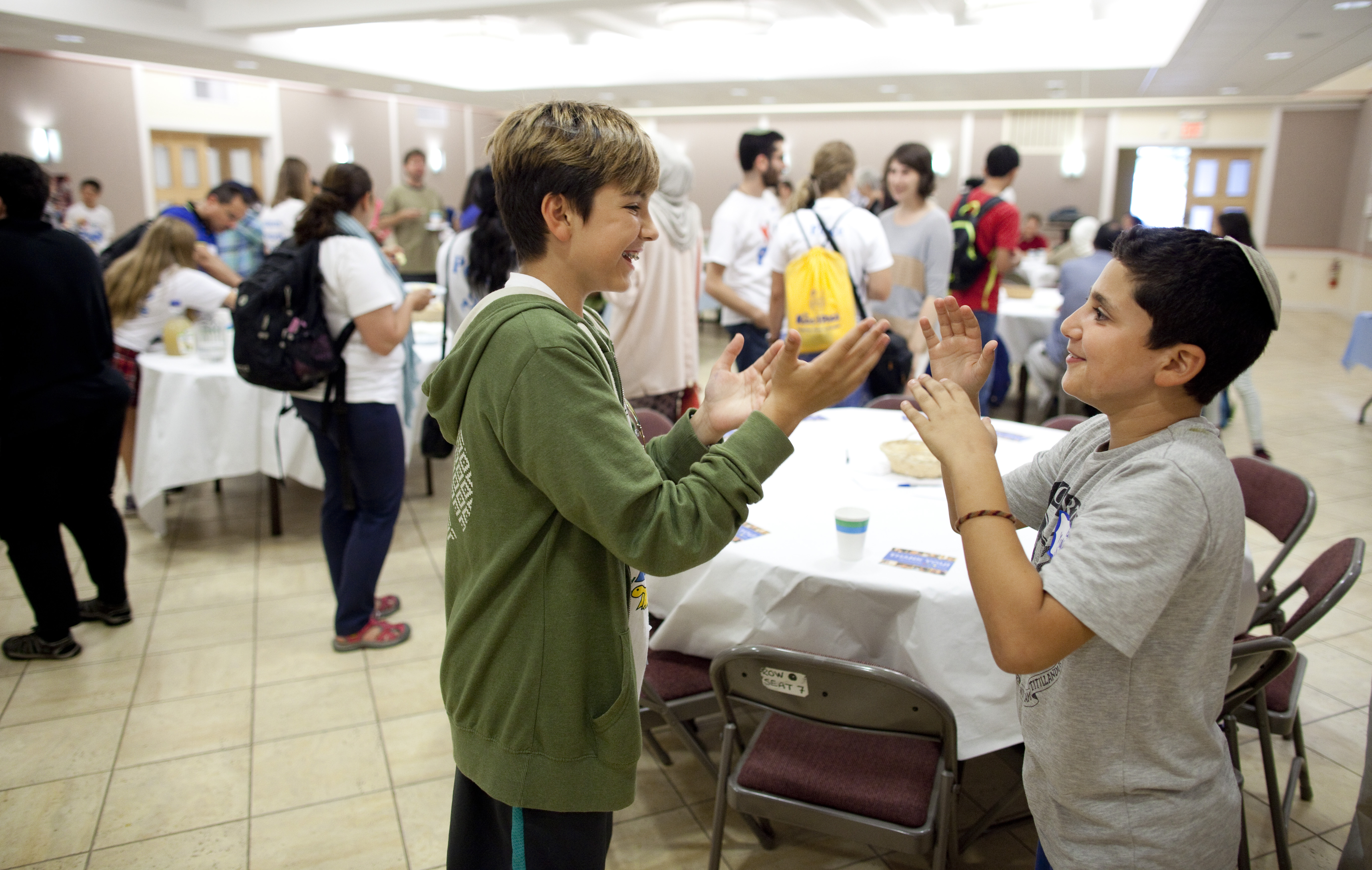 Ali Huda (left), a Boston Muslim, and Yuval Zaouy of Jerusalem, who is Jewish, played a game during a reception for the Kids4Peace camp on Sunday.