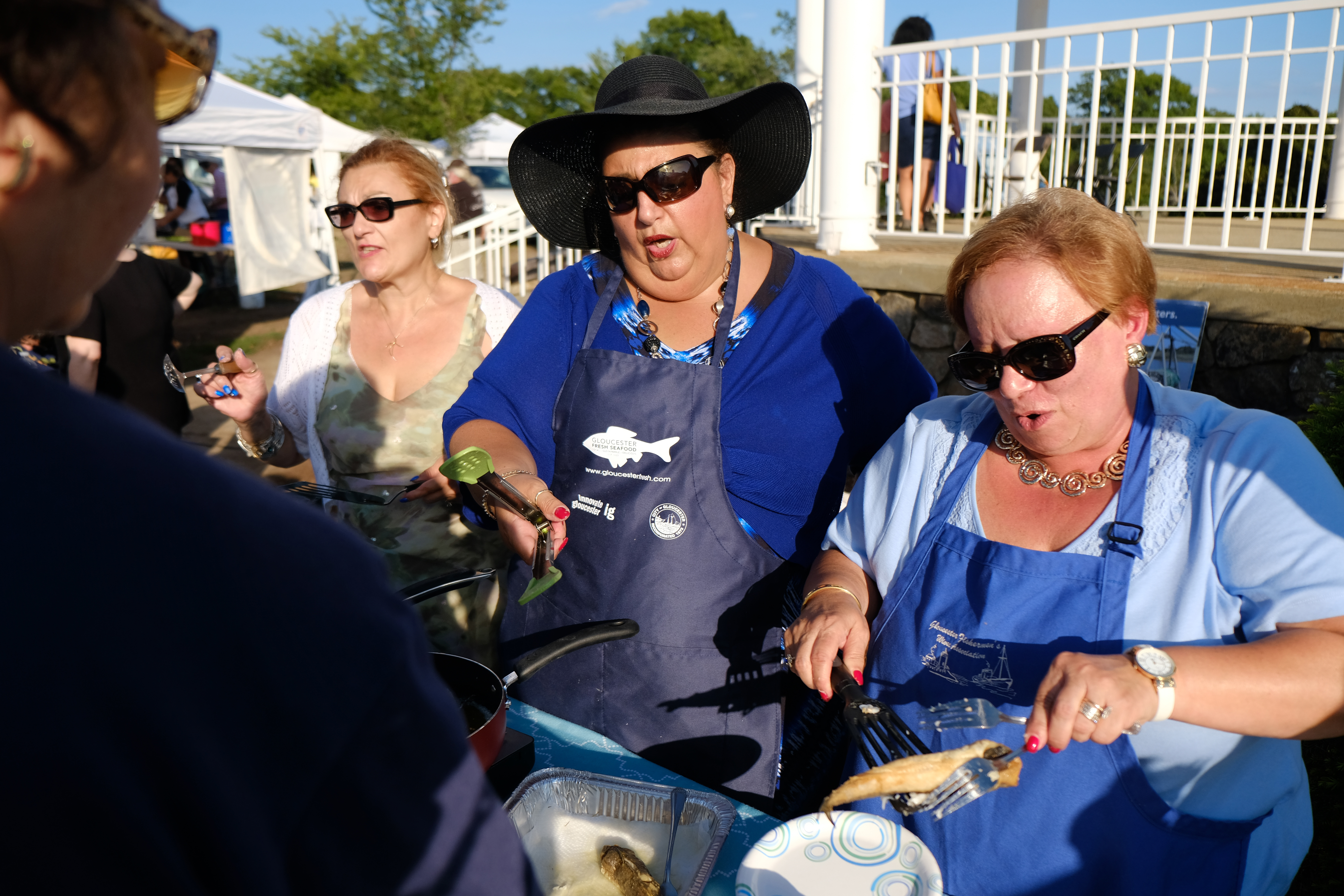 Mayor Sefatia Romeo Theken (center) cooks with Angela Sanfilippo (right) of the Gloucester Fishermen's Wives Association and Maria Cannavo (left) during a demonstartion at at the Seafood Throwdown.