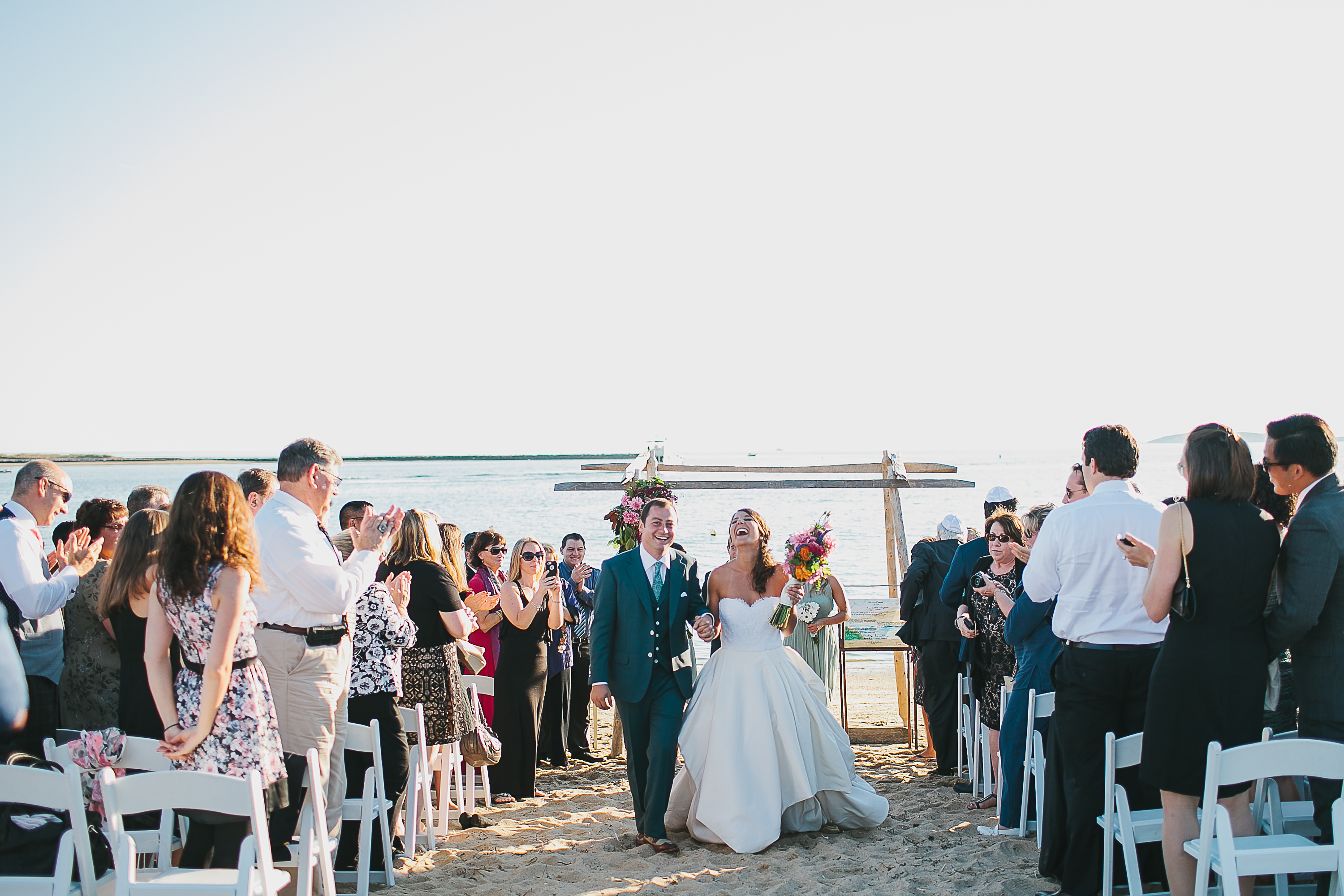 In their shoe-optional beach ceremony, the couple exchanged vows under a chuppah made of old fence posts.