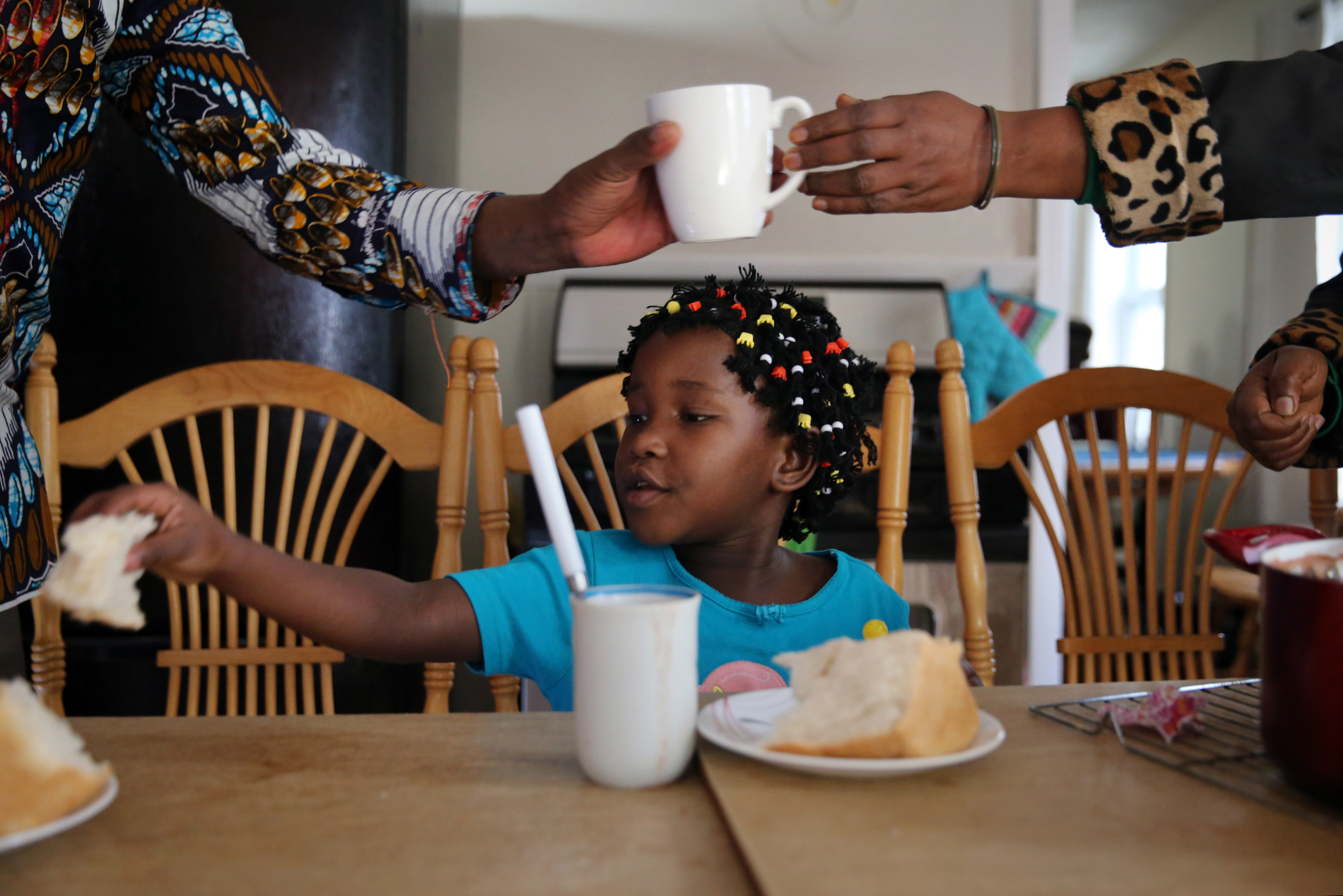 Seven-year-old Sarah Bayavuge (above) sat at the table in her family’s home in Lowell.