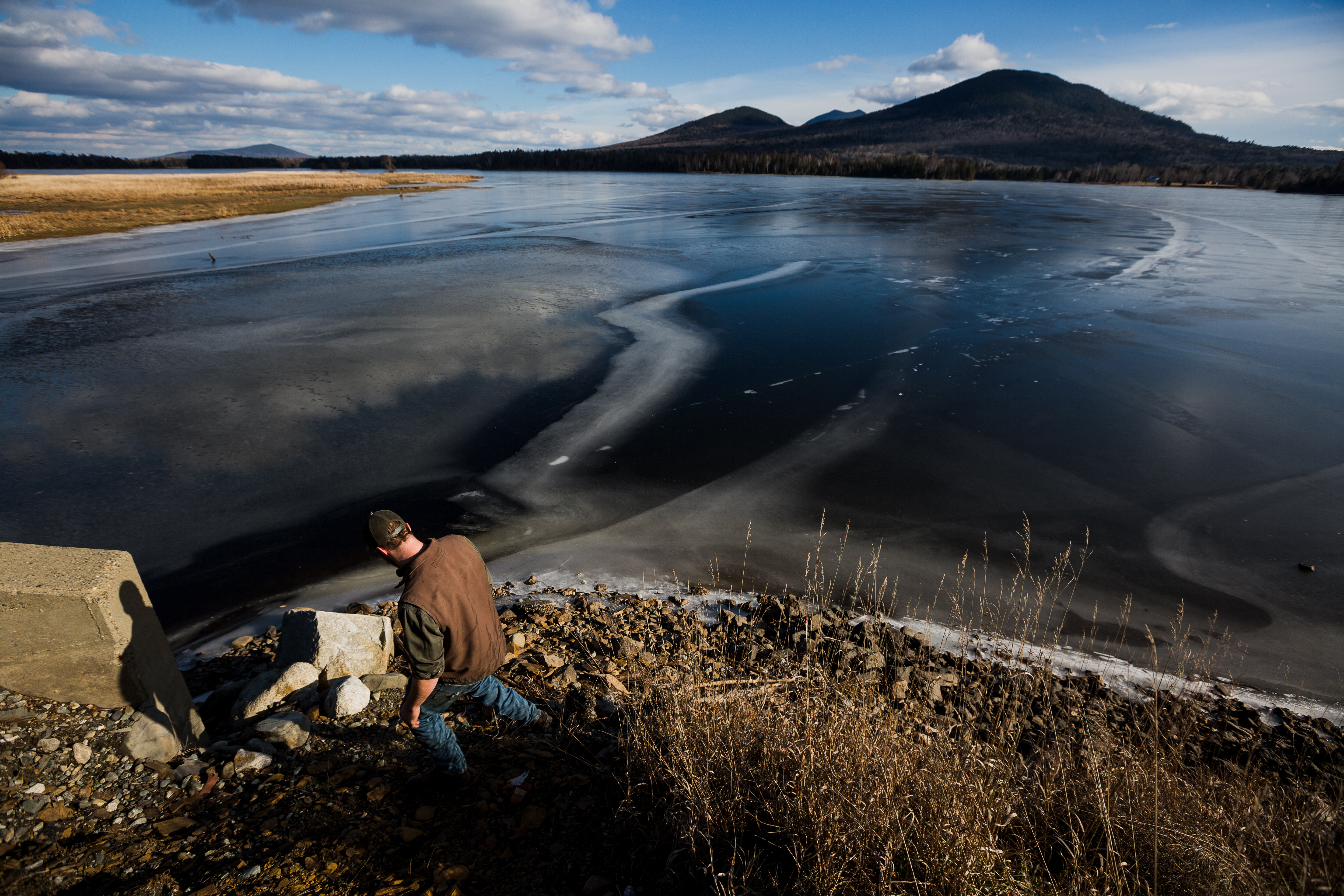 Justin Wyman walked down to the edge of Flagstaff Lake, where a broken path through the ice can be seen, in Stratton, Maine.