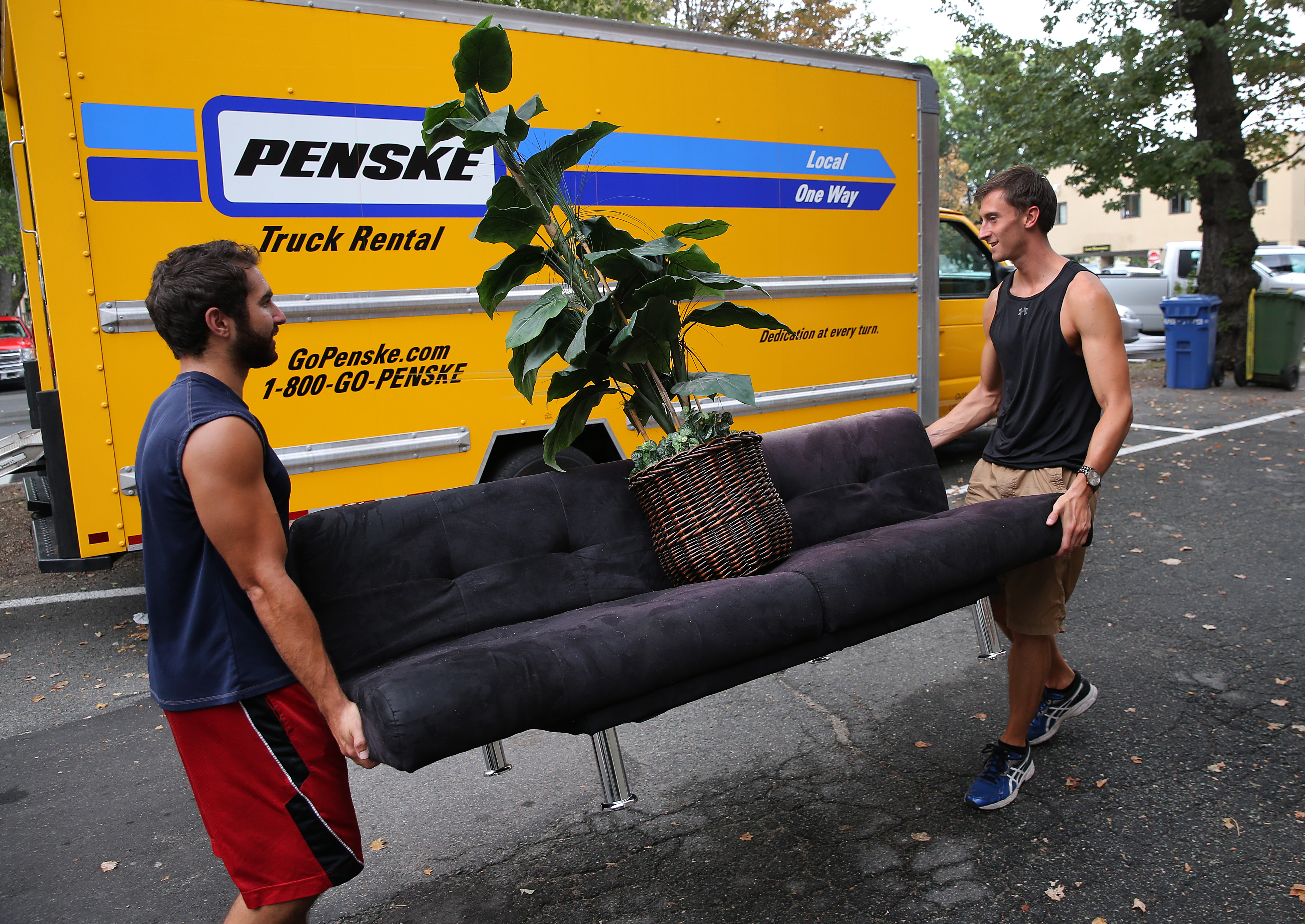 Edward Cardona and Cameron Secorsky balanced a plant while moving a couch in Allston.