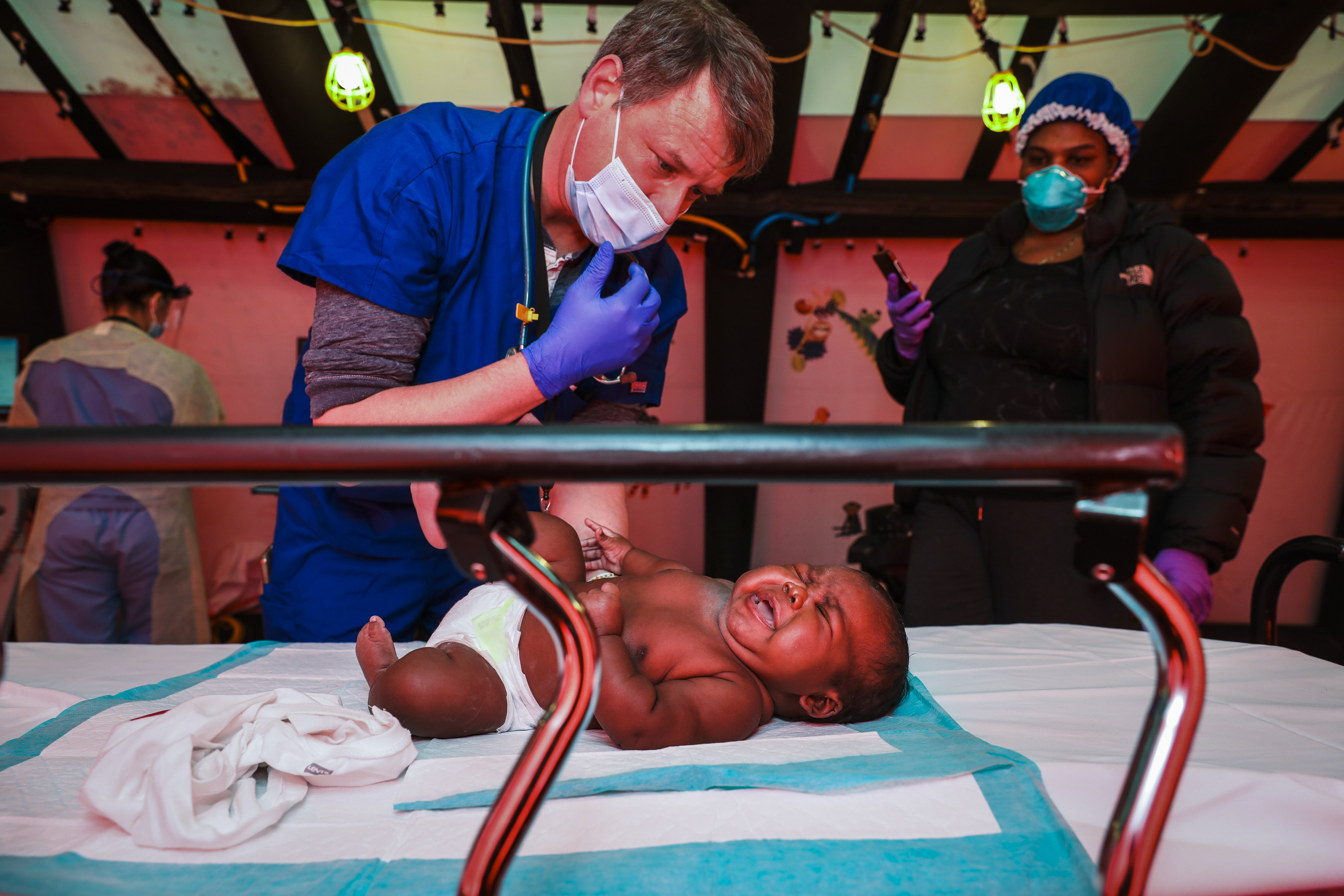Boston Medical Center Dr. Jack Maypole performed a routine checkup on 2-month-old Alfredo Guillaume while his mother Norelia looked on as they stand in a pediatrics tent set up outside of Boston Medical Center.