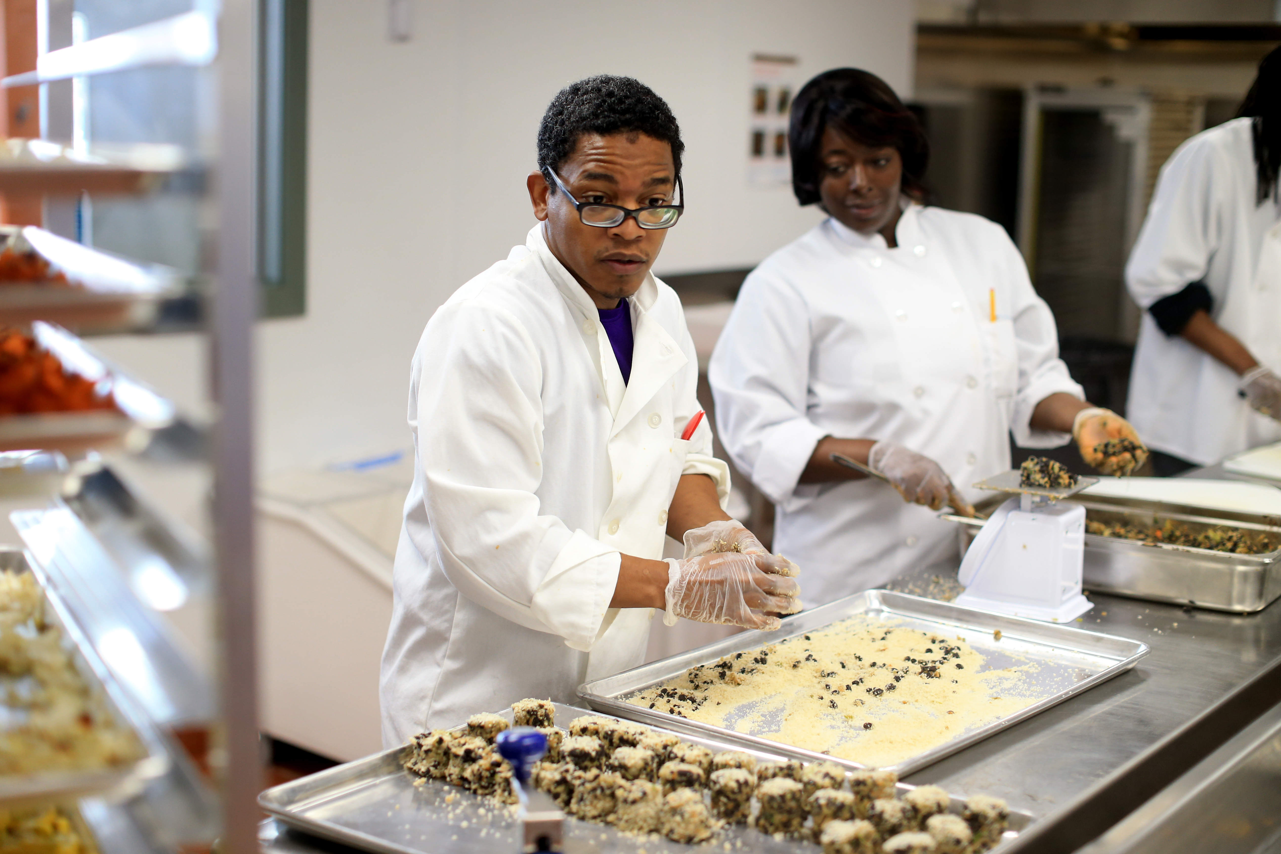 Executive chef Ismail Samad (left) and other workers prepared food in the Daily Table’s Dorchester kitchen.