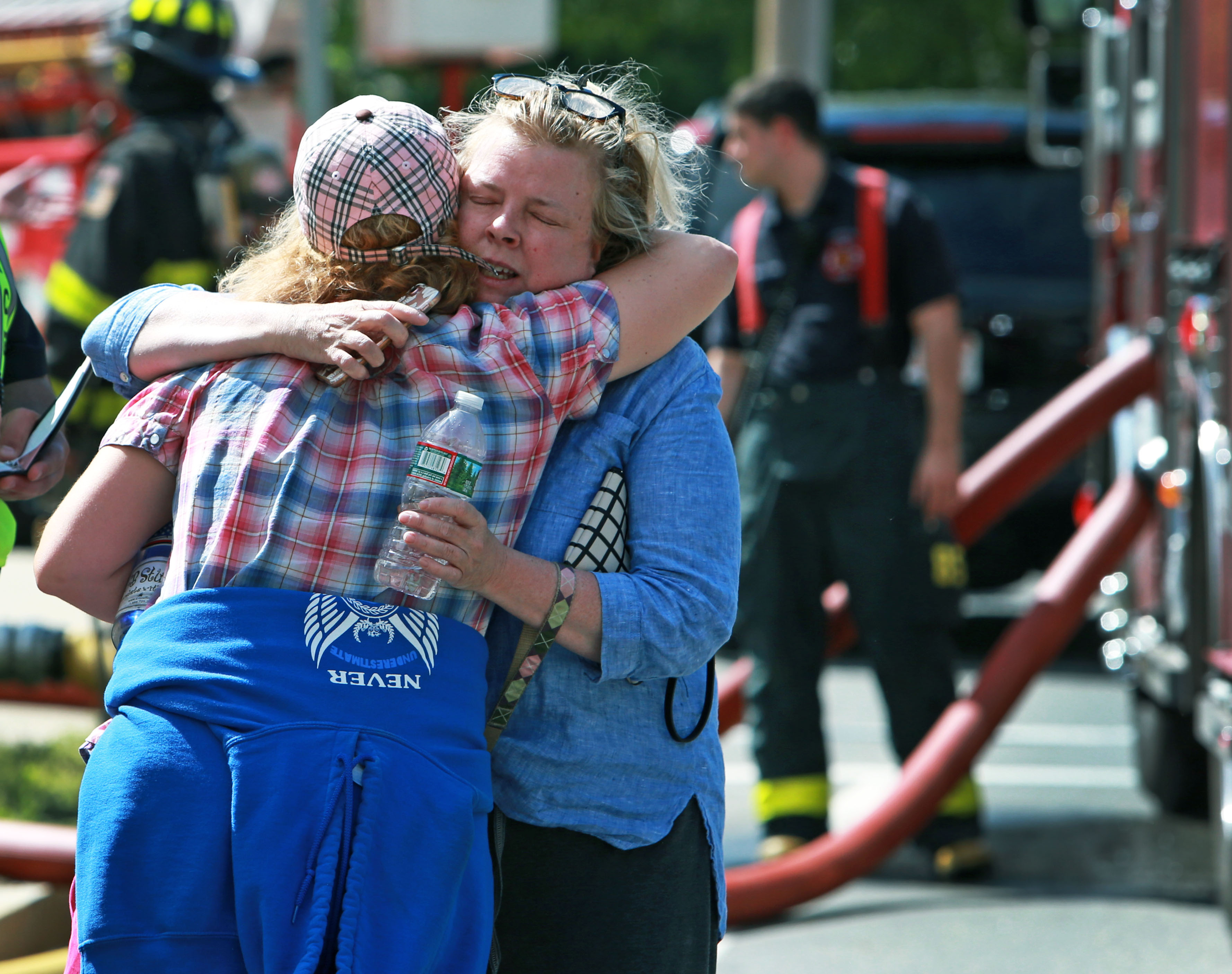 Melanie Murphy (right), a resident of the condos, who lived on the first floor and escaped the blaze was comforted by a friend.