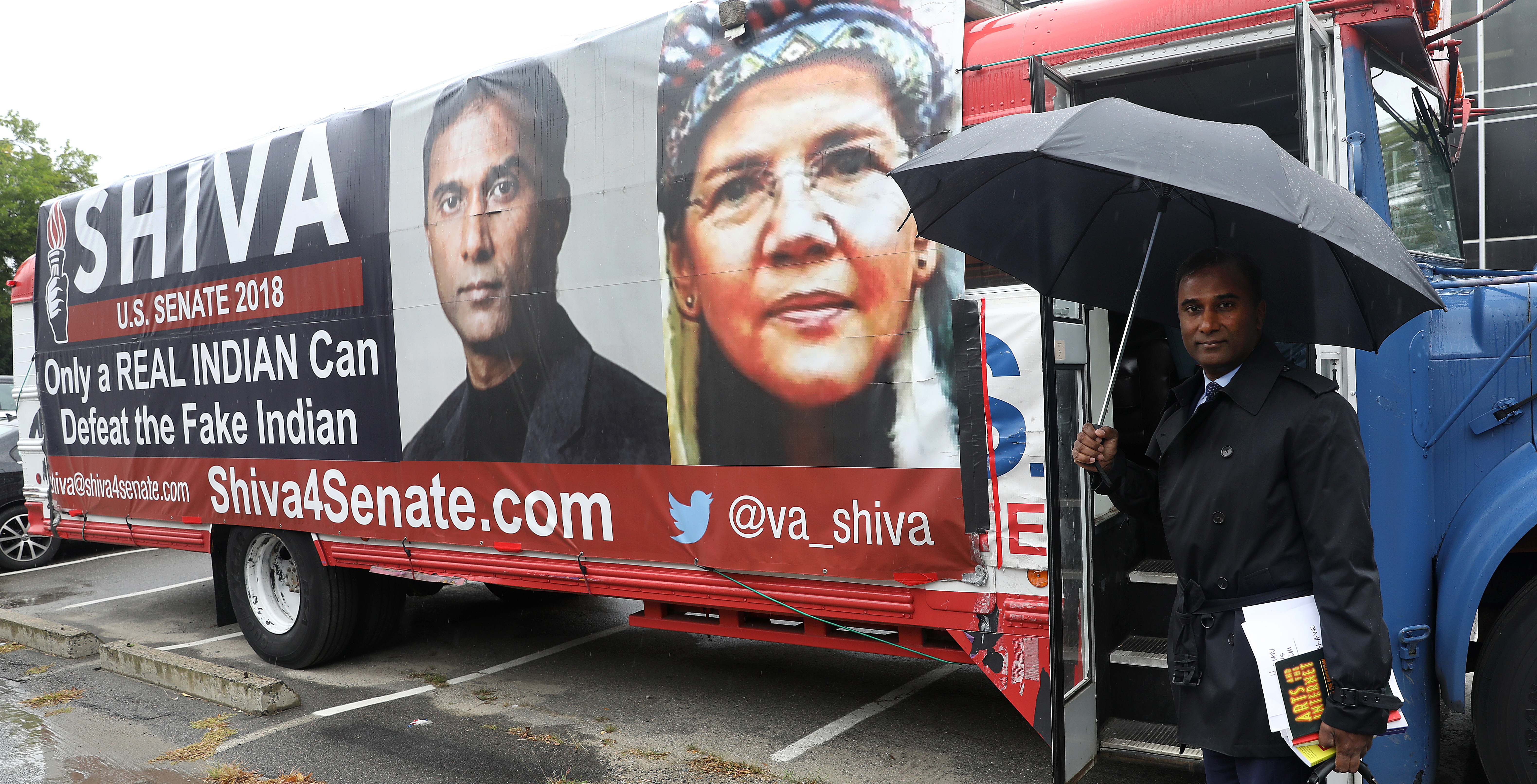Shiva’s campaign bus with sign that says “Only a REAL INDIAN Can Defeat the Fake Indian,” and includes a picture of himself next to a Photoshopped image of Warren in a headdres.