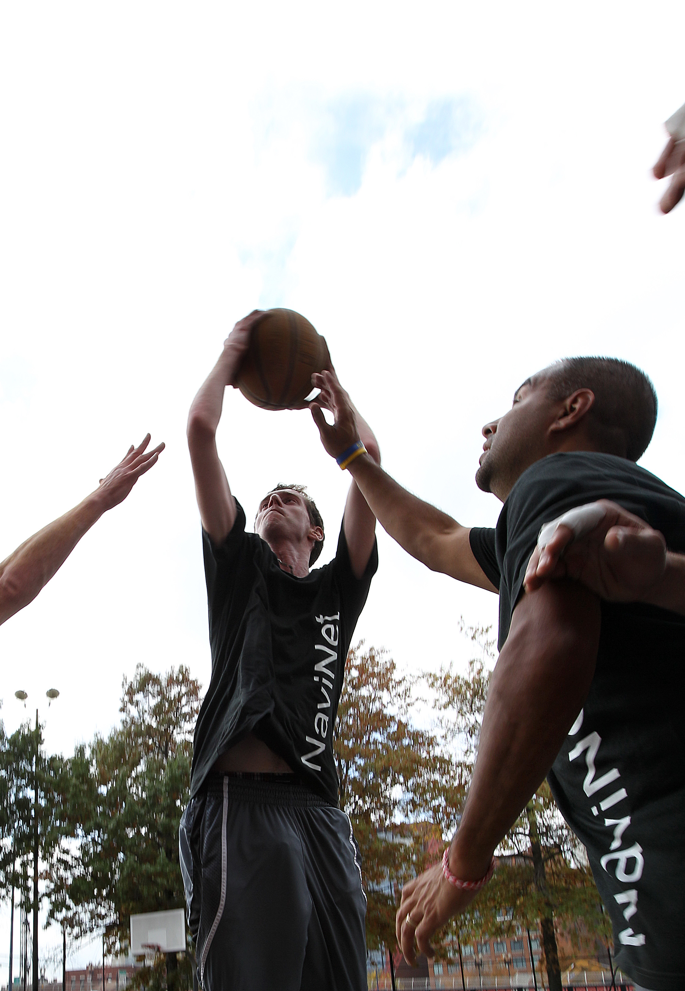 NaviNet’s Chris Paine (left) and Frank Figueroa play their weekly basketball game. The company sponsors teams in several sports — including cricket.