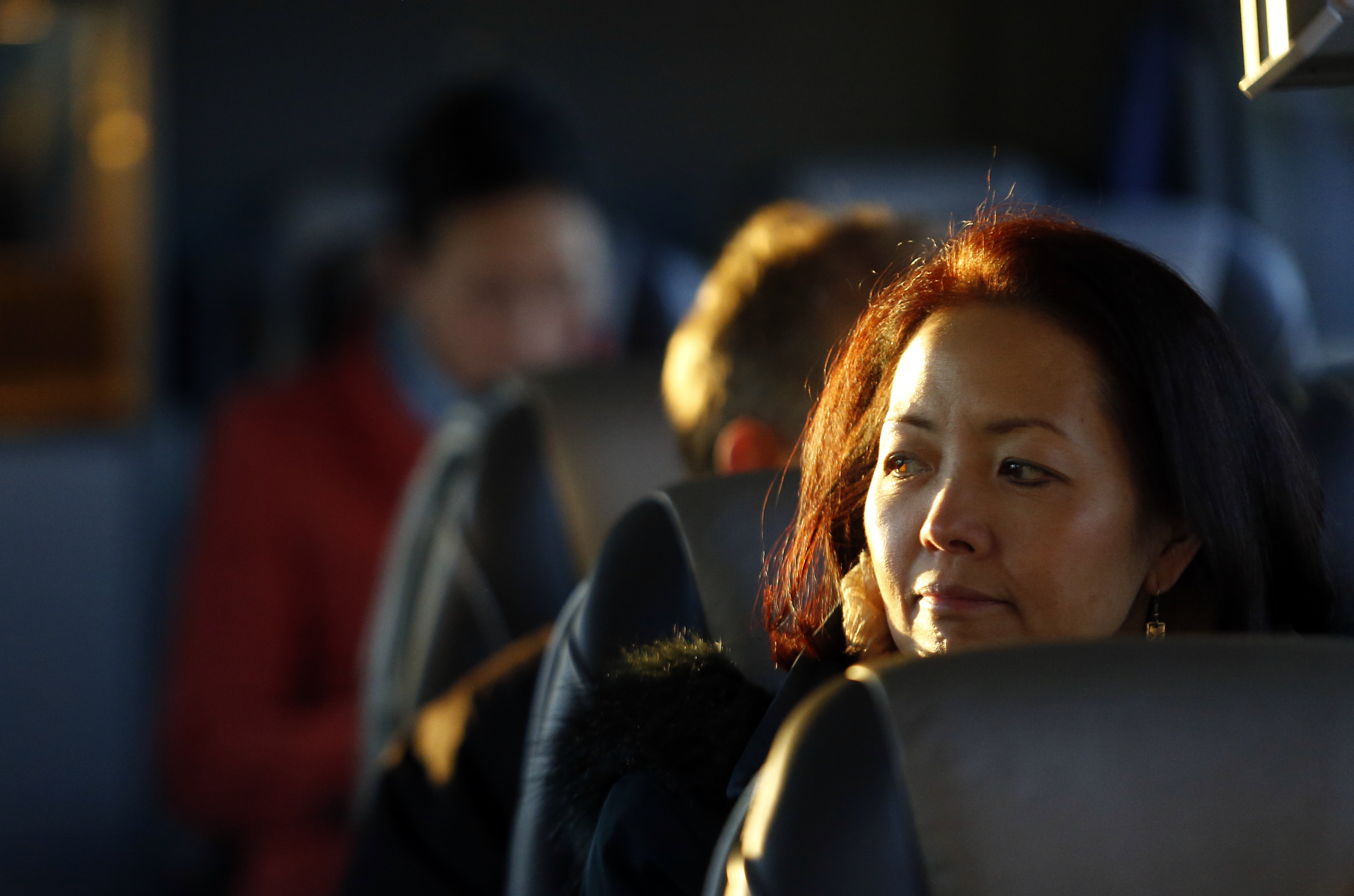 Biogen Idec employee Susan Okuhara looks out the window aboard the Biogen Bus that shuttles employees between the Weston Biogen campus and Cambridge Biogen campus along the Massachusetts Turnpike.