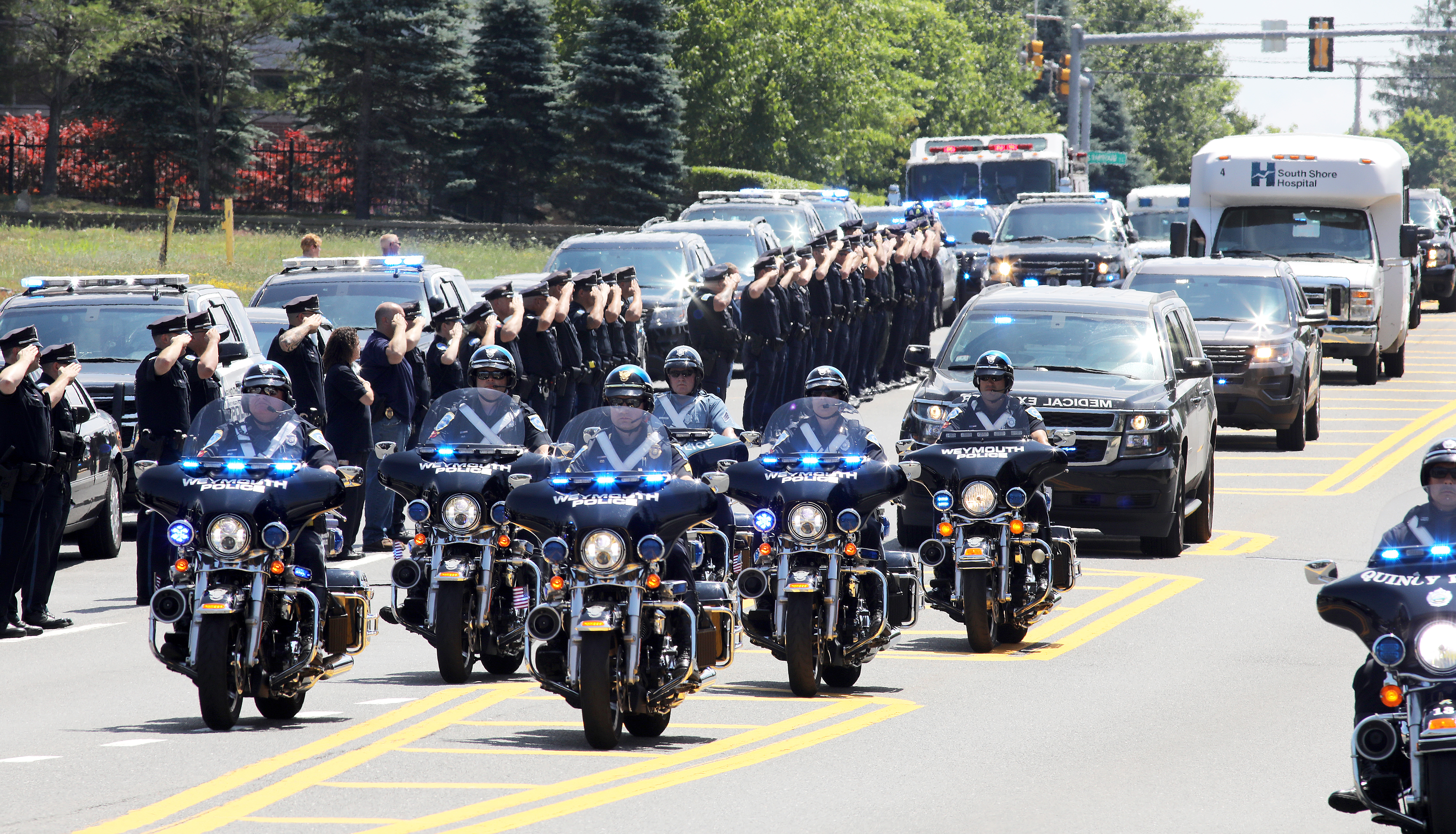 Police in Weymouth saluted along Main Street as the body of officer Michael Chesna was brought to the medical examiner’s office in Boston.