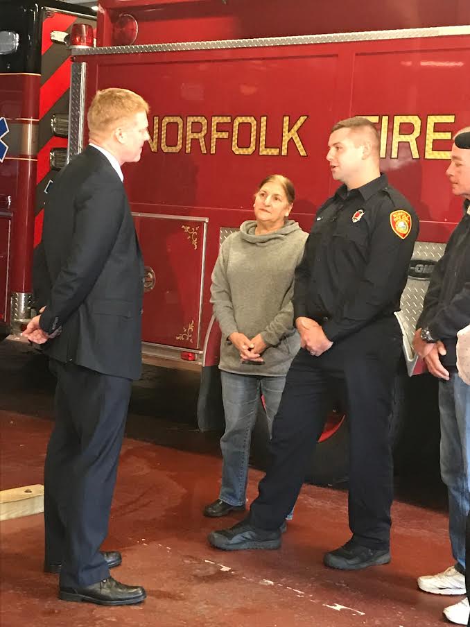 Podsiadlo, left, and Brady, right with his parents, talk at the Norfolk fire department.