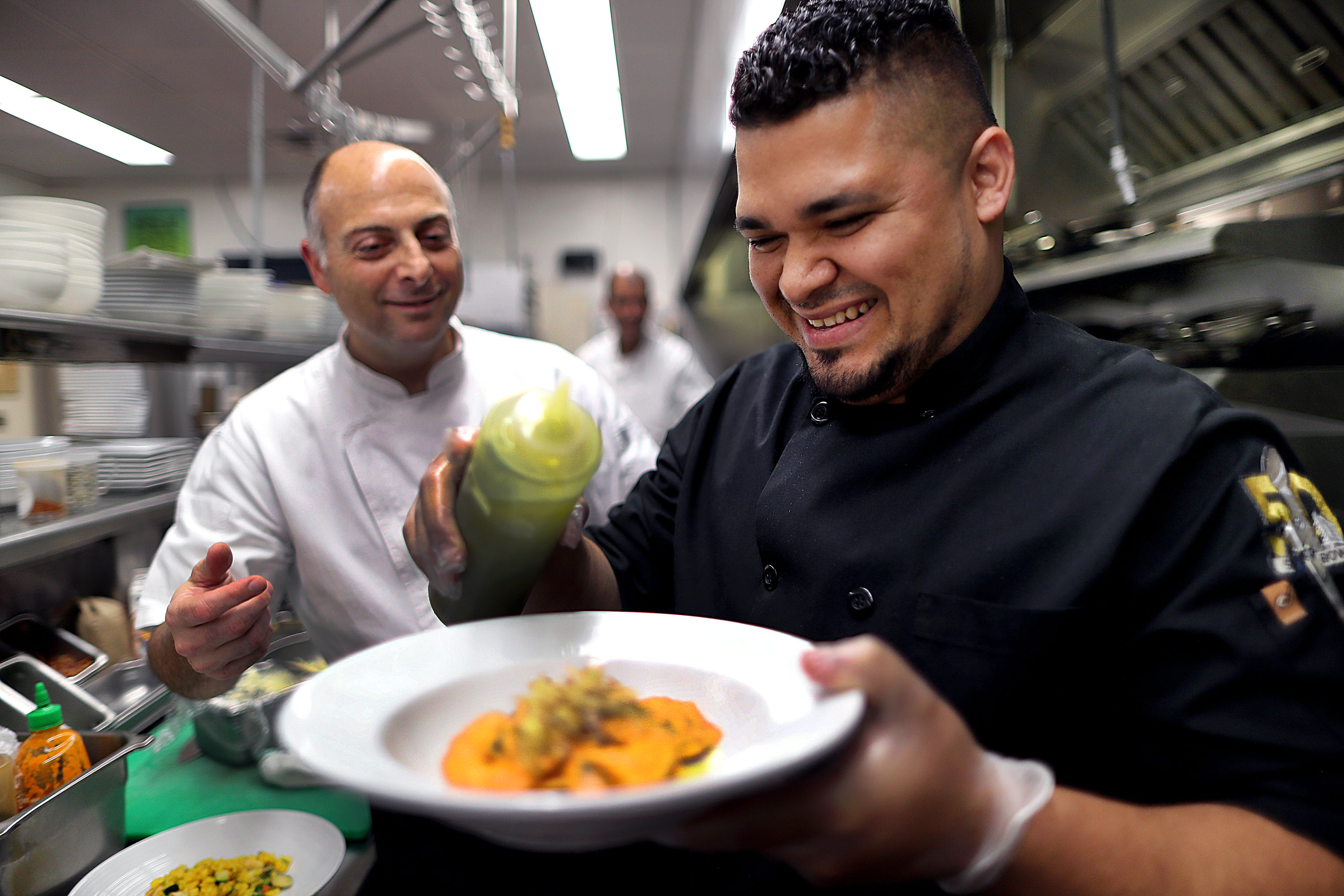 Cook Edgar Valenzuela (right) in the kitchen at the Hyatt Hotel in Downtown Crossing, thanks to the Instawork app that executive chef Kelly Armetta (left) used to find him. Valenzuela works full time at the Hyatt, but uses the app to pick up shifts on his days off.