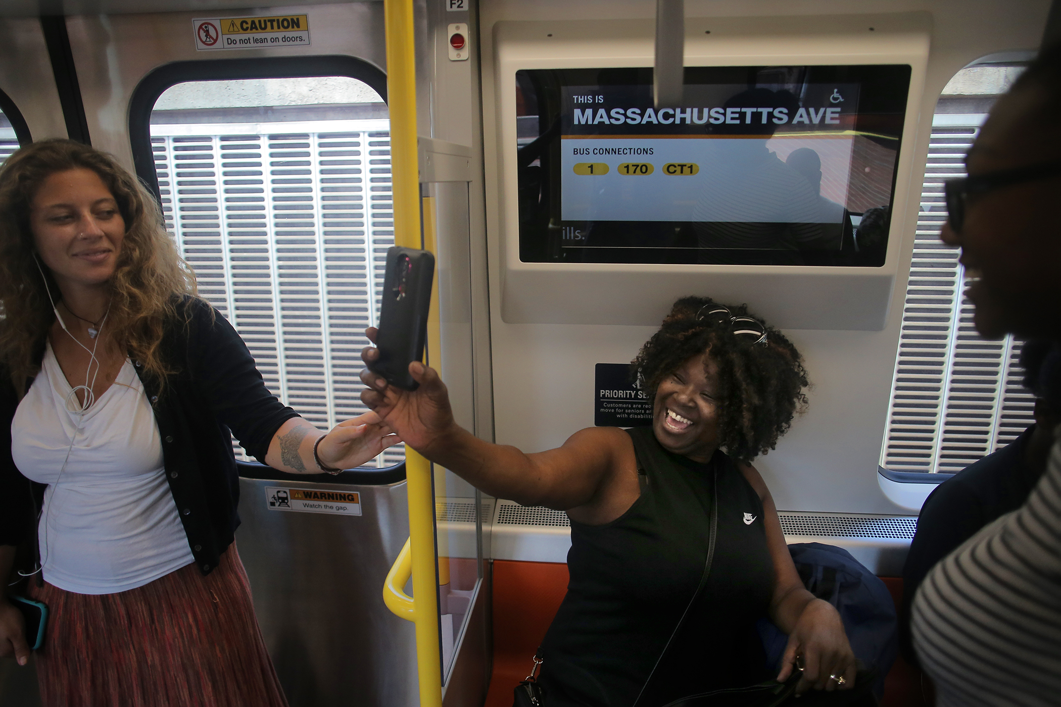 Seated under a new information screen, Roxbury resident Antoinette Carter was happy as she took pictures of the new train.