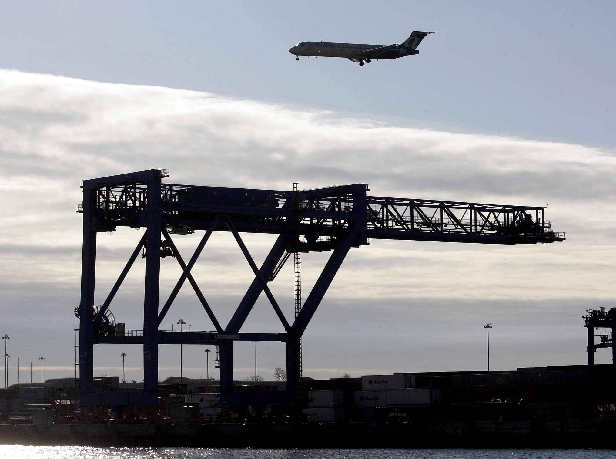 A plane approached Logan Airport above the cranes at Conley Terminal.