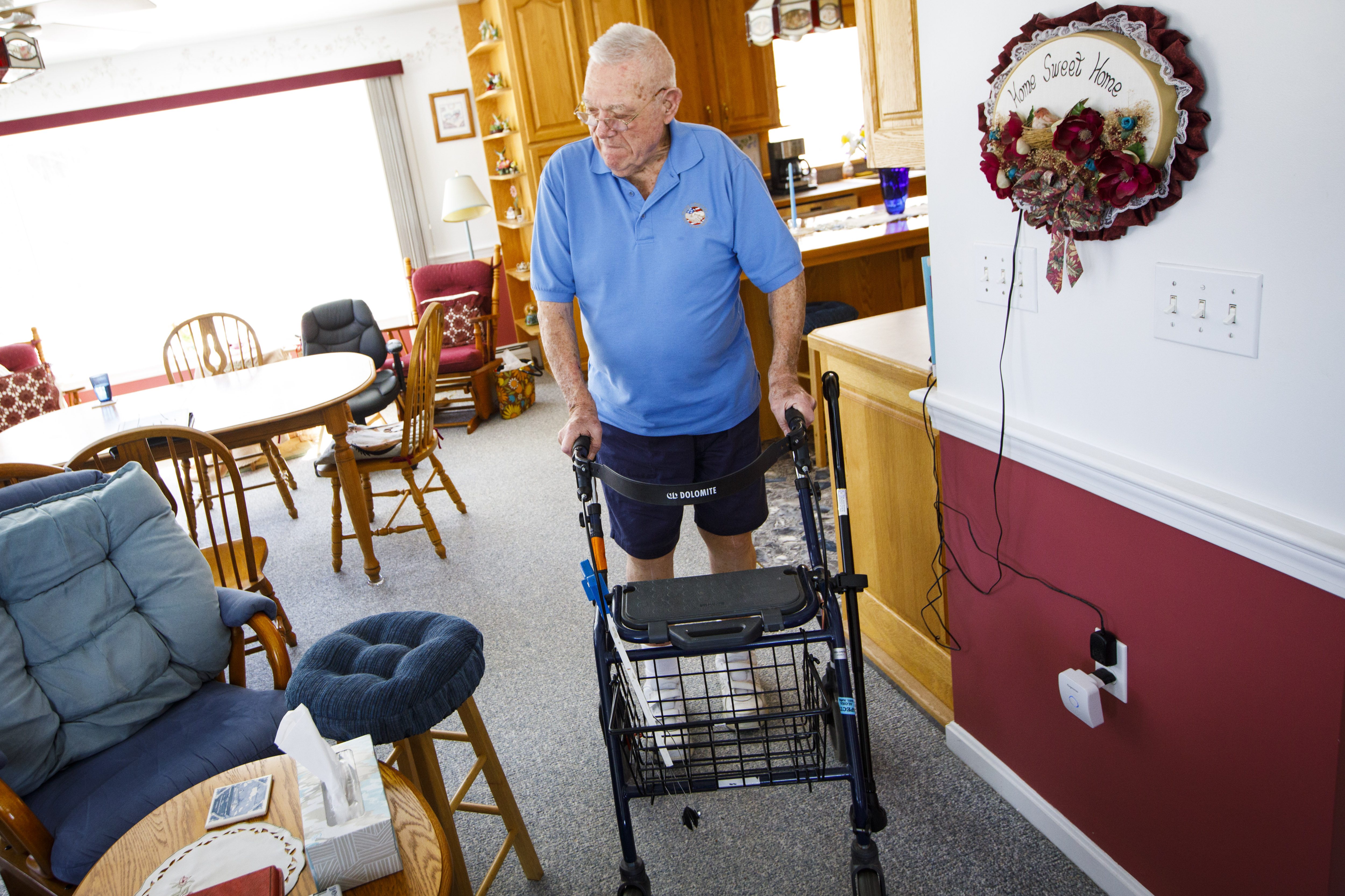 Robert C. McWhinnie pushes his walker through his home in Gilmanton, N.H. The 85-year-old Korean War veteran has an inoperable tumor around his upper spine, limiting his mobility. For 21 years, the tumor’s growth went undetected despite many visits to the VA hospital in Manchester, his lawyer says.