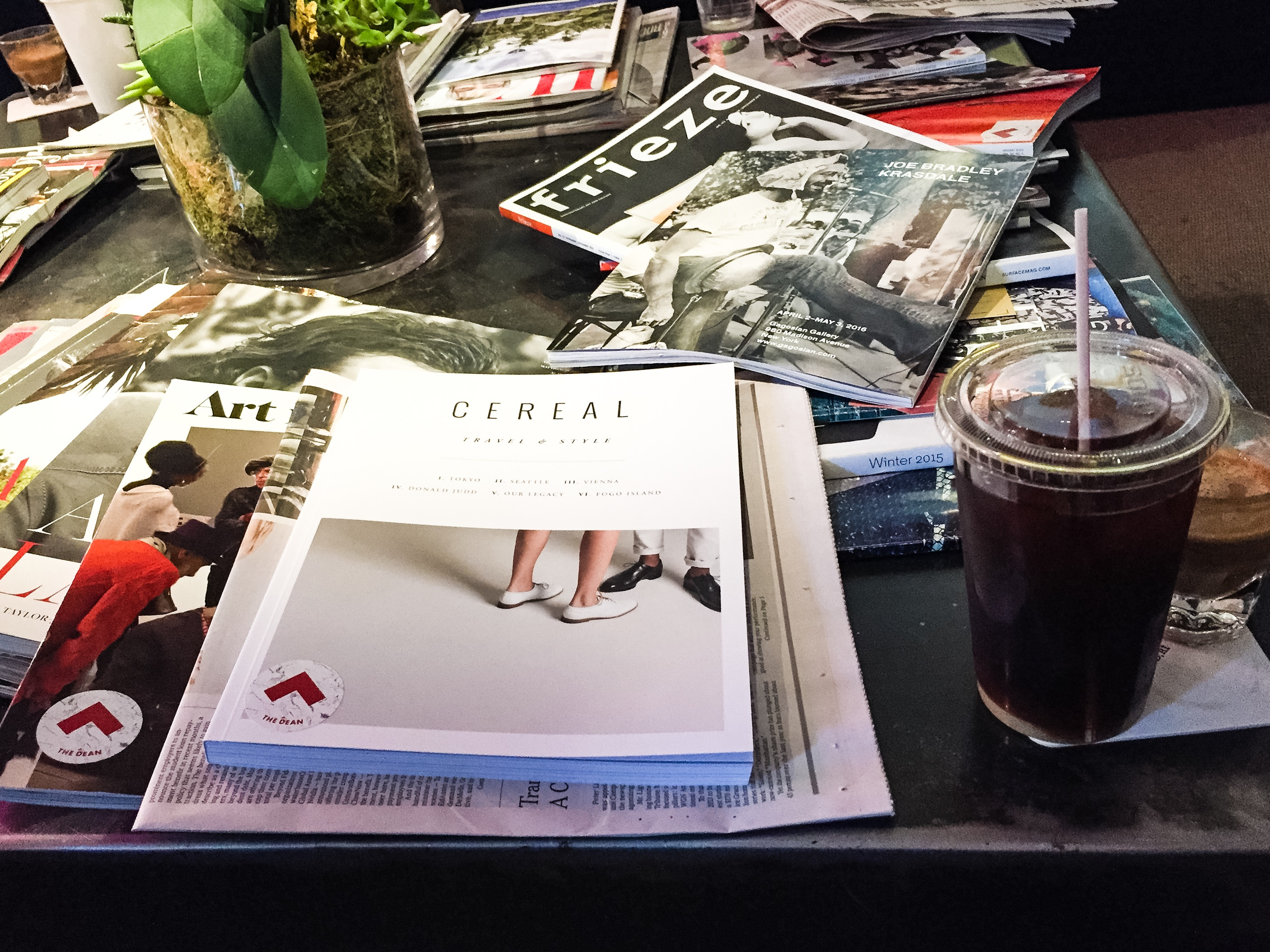 Coffee, art journals, and niche digests on a center table in Bolt.