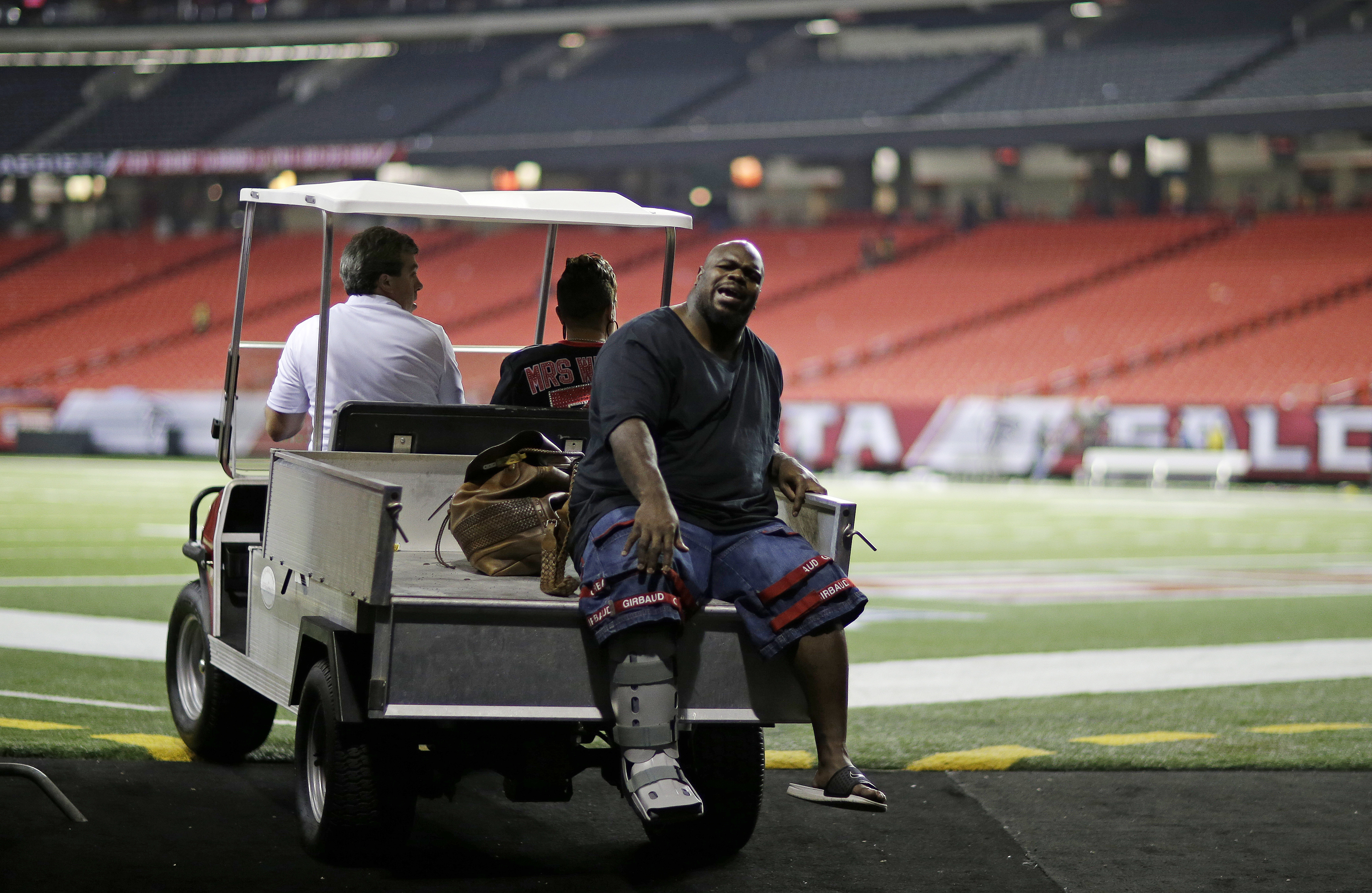 His wife Bianca in the passenger seat, Patriots lineman Vince Wilfork is transported out of the Georgia Dome in a protective boot after tearing his Achilles’ last season against the Falcons.