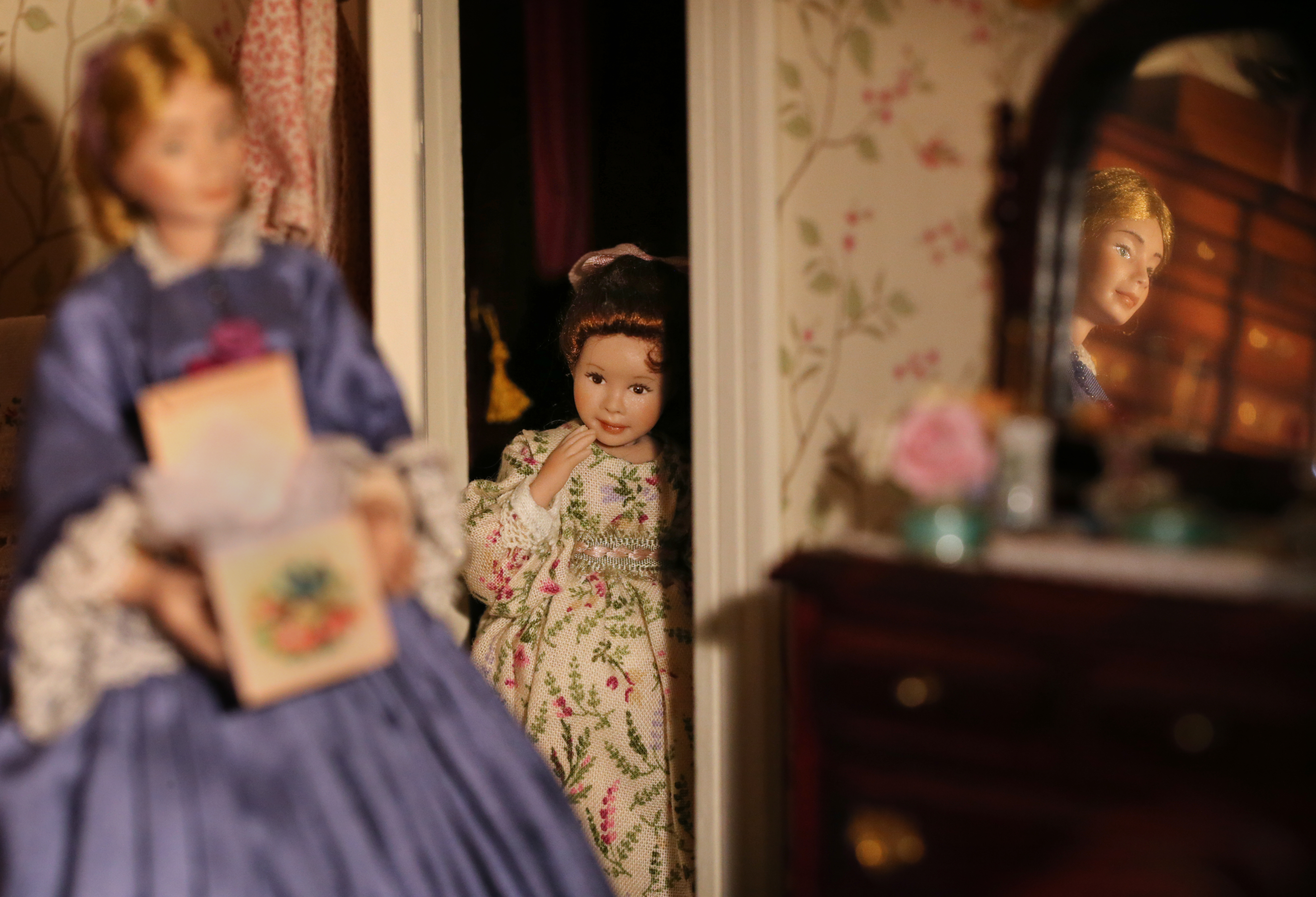 Emma wraps Christmas presents while her daughter, Jane, peeks through the door.