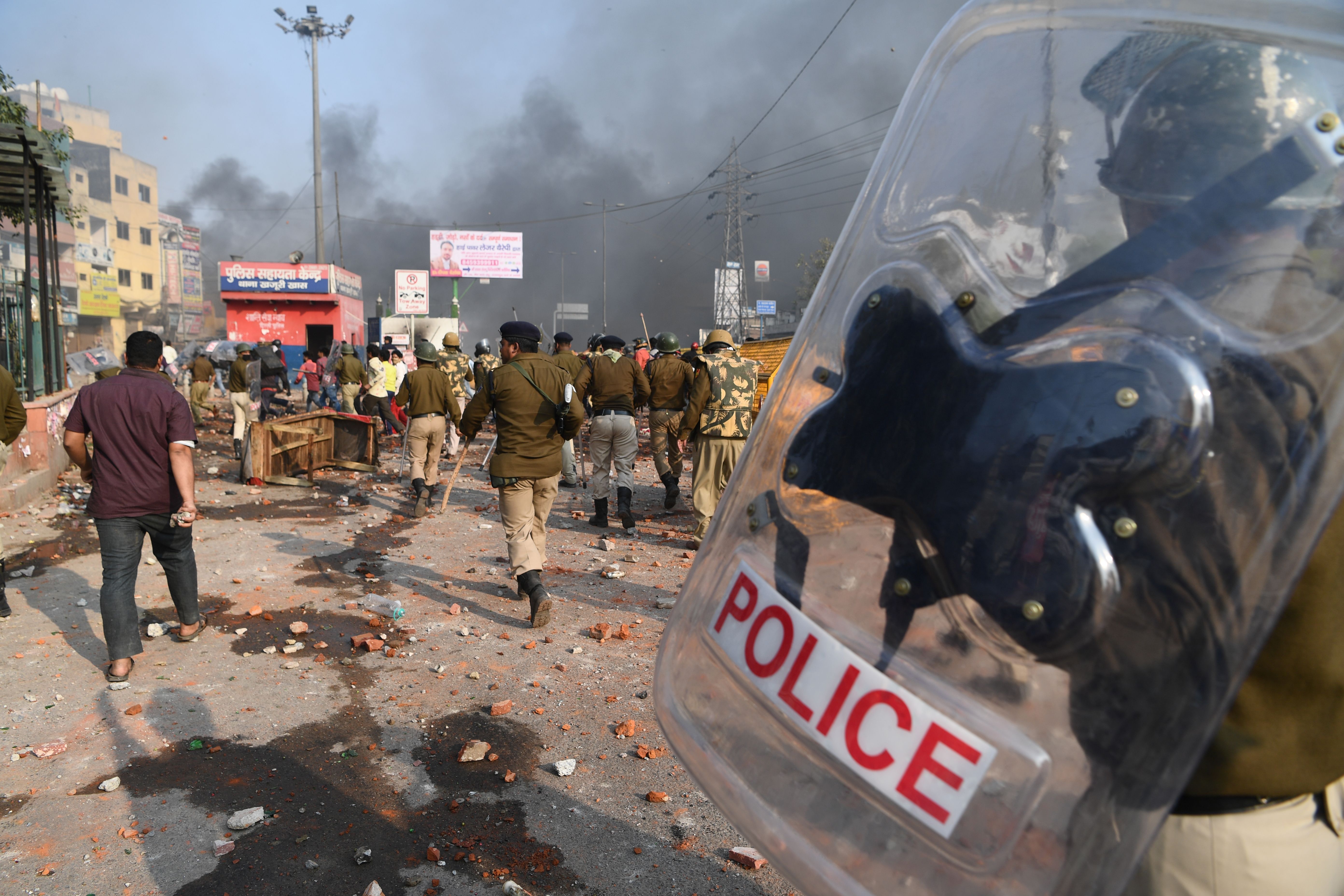 Riot police walked along a road scattered with stones following clashes between supporters and opponents of a new citizenship law in New Delhi Monday ahead of President Trump's visit.