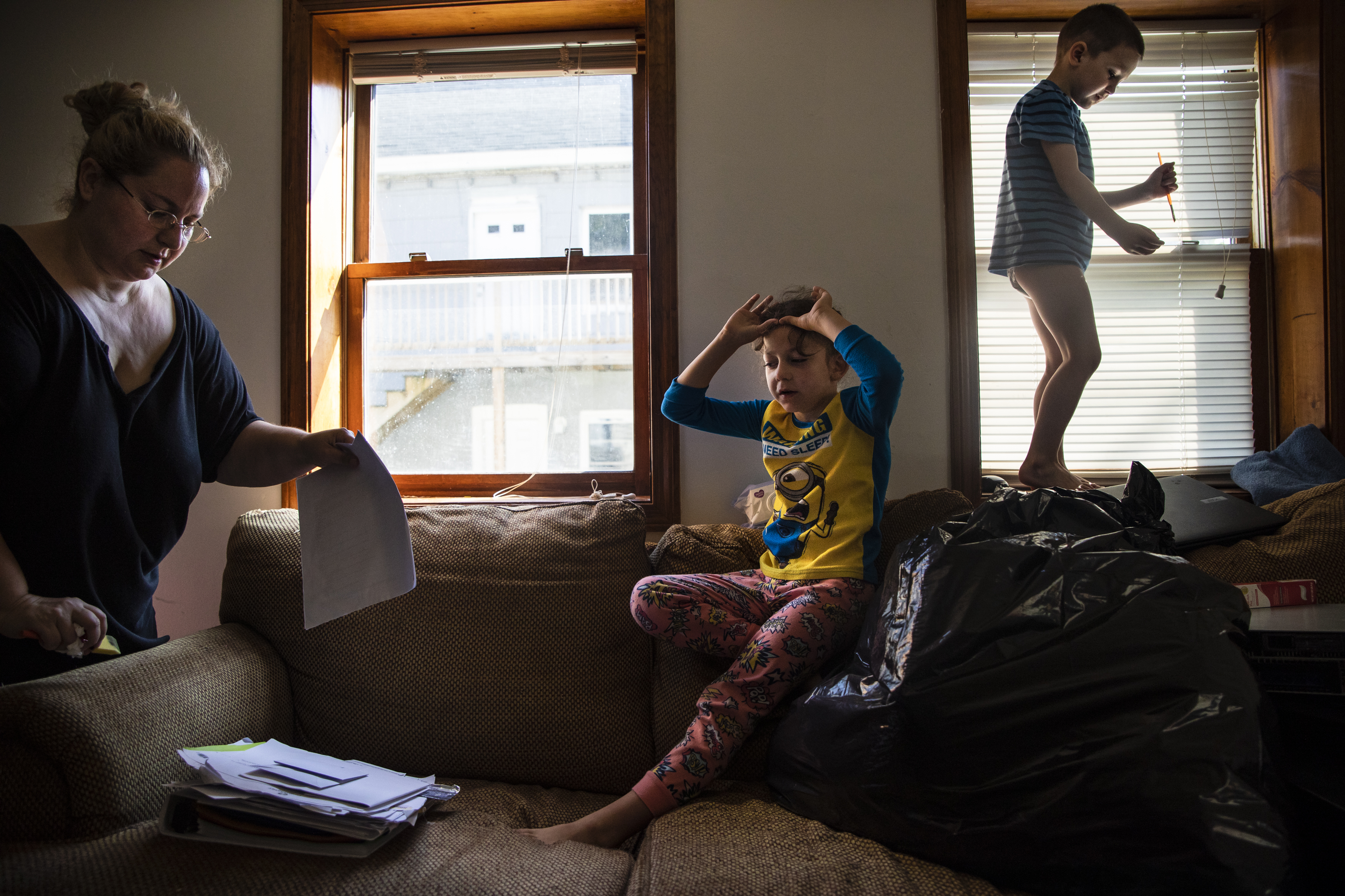Mariah organized paperwork while Evan (center) and Dylan played on the couch. “It was really hard going through all the school work from the kids,” Mariah reminisced. “How happy and hard they’ve all worked. They’re kicking ass while I’m barely hanging on as an adult.” She has kept a methodical archive of her children's education and special care over the past several years.