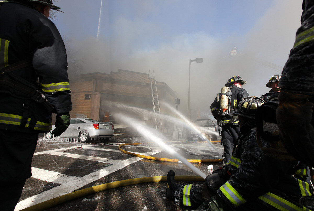 Firefighters battle a 4-alarm fire in a commercial block at 160 Chestnut Hill Avenue in Brighton.