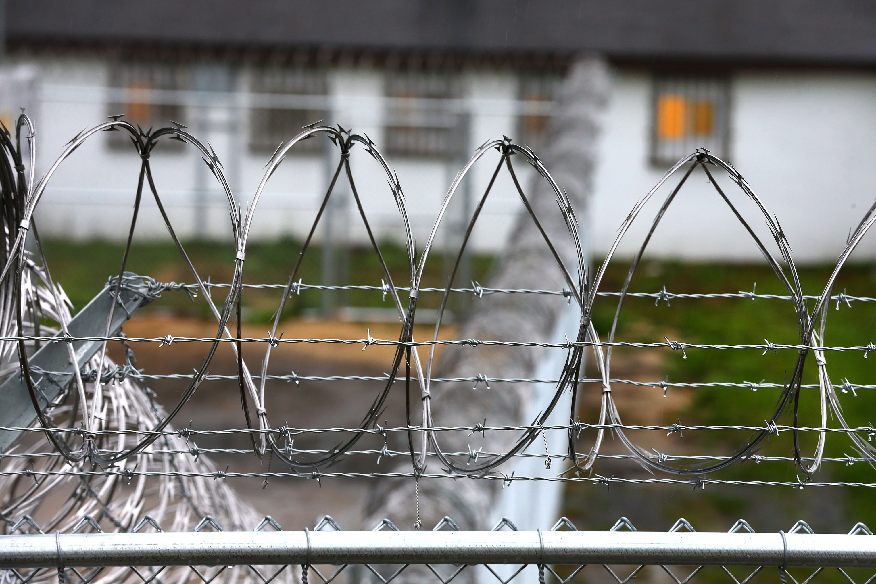 The Plymouth facility is surrounded by a tall fence and razor wire.