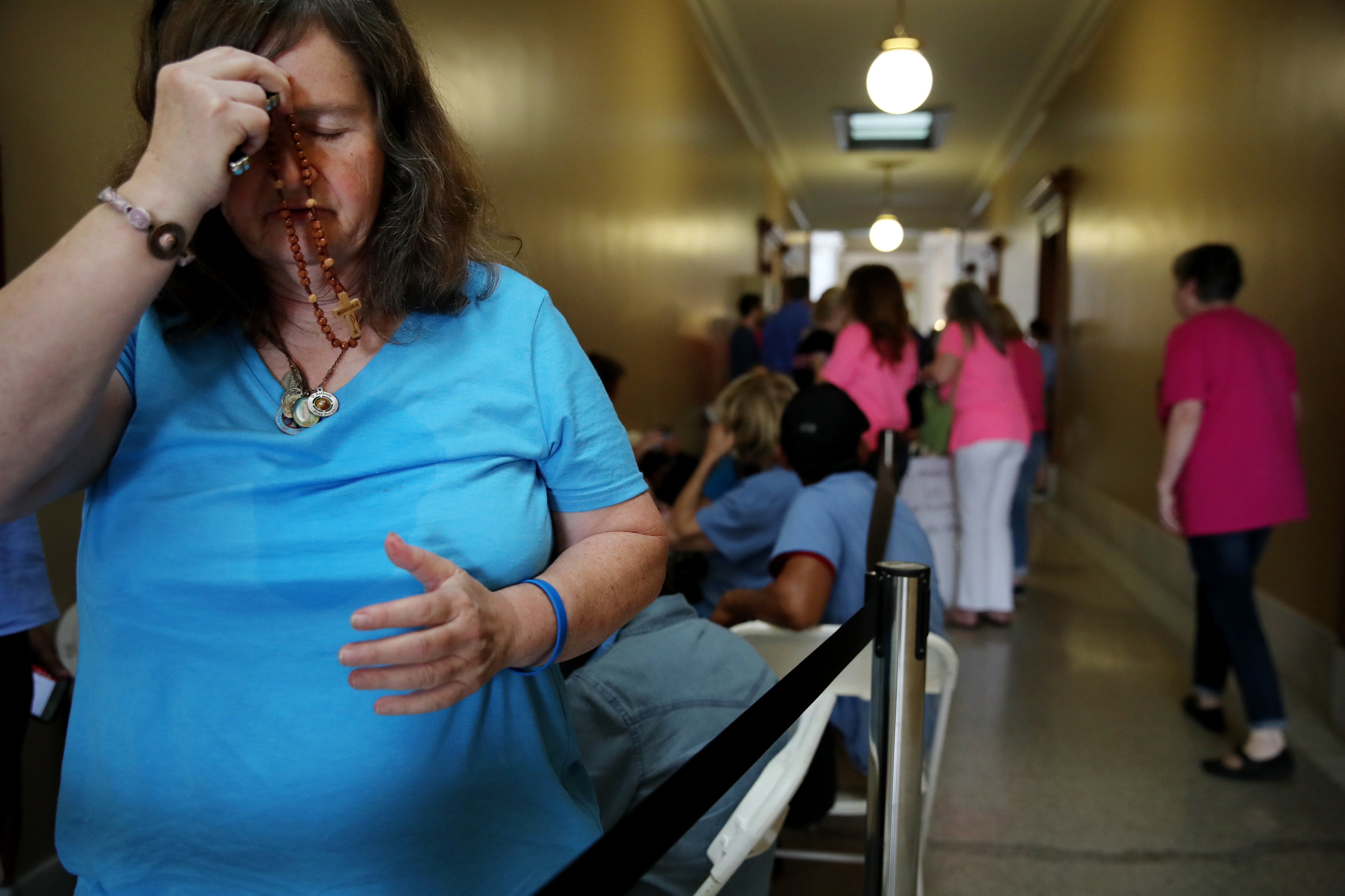 Mary Kavanagh of St. Charles Borromeo parrish prayed in a hallway at the State House in Providence.