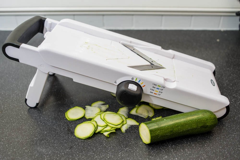 TIP: A mandoline or V-slicer (a slicer with its blades set in a V-shape, pictured) is handy for slicing zucchini consistently and very, very thinly — shoot for 1/16-inch rounds, almost paper thin. You can also use a vegetable peeler to shave thin strips for salads.