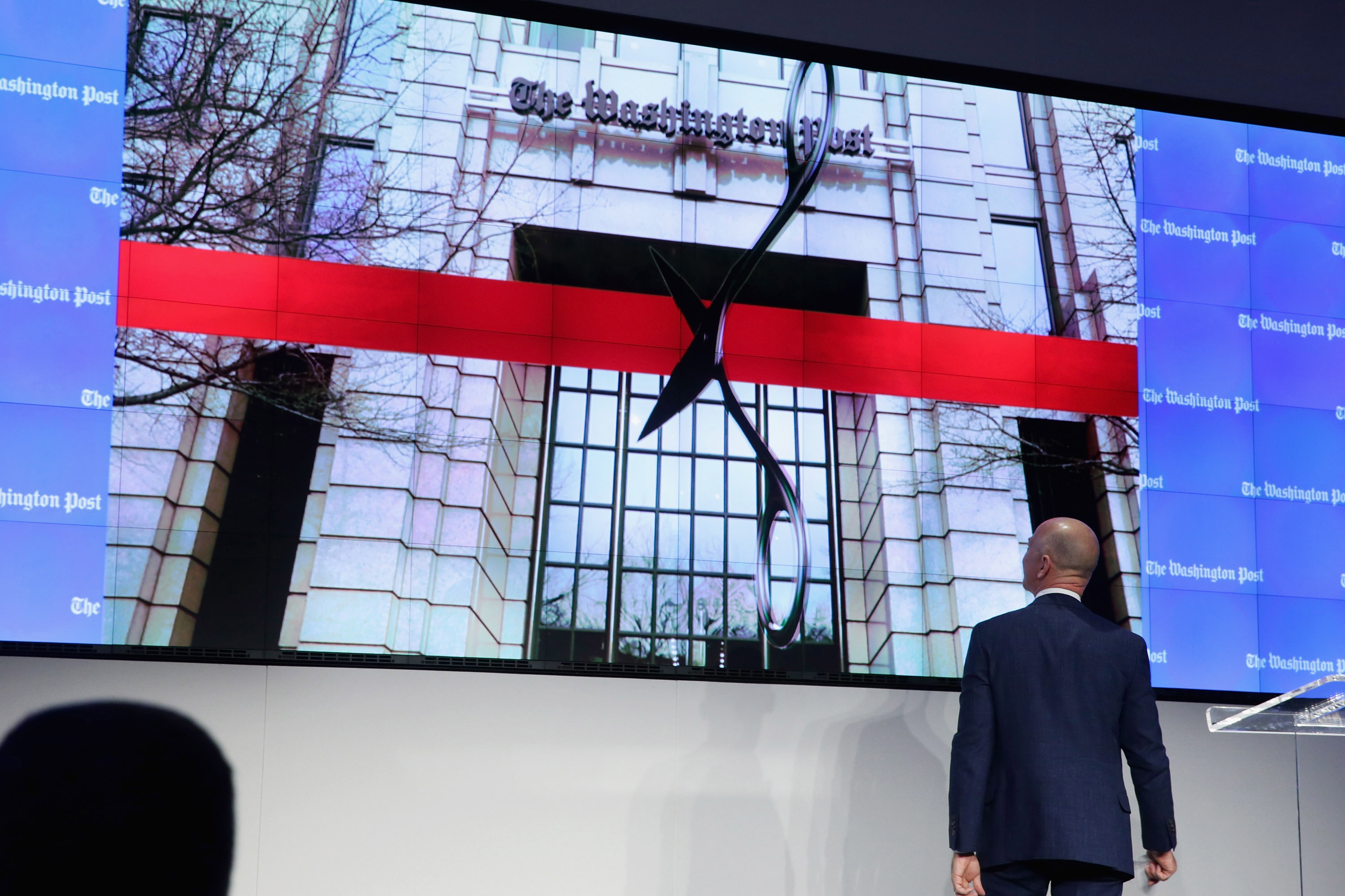 Jeff Bezos conducts a “digital ribbon cutting” during the opening ceremony of the Washington Post’s new headquarters on January 28, 2016.