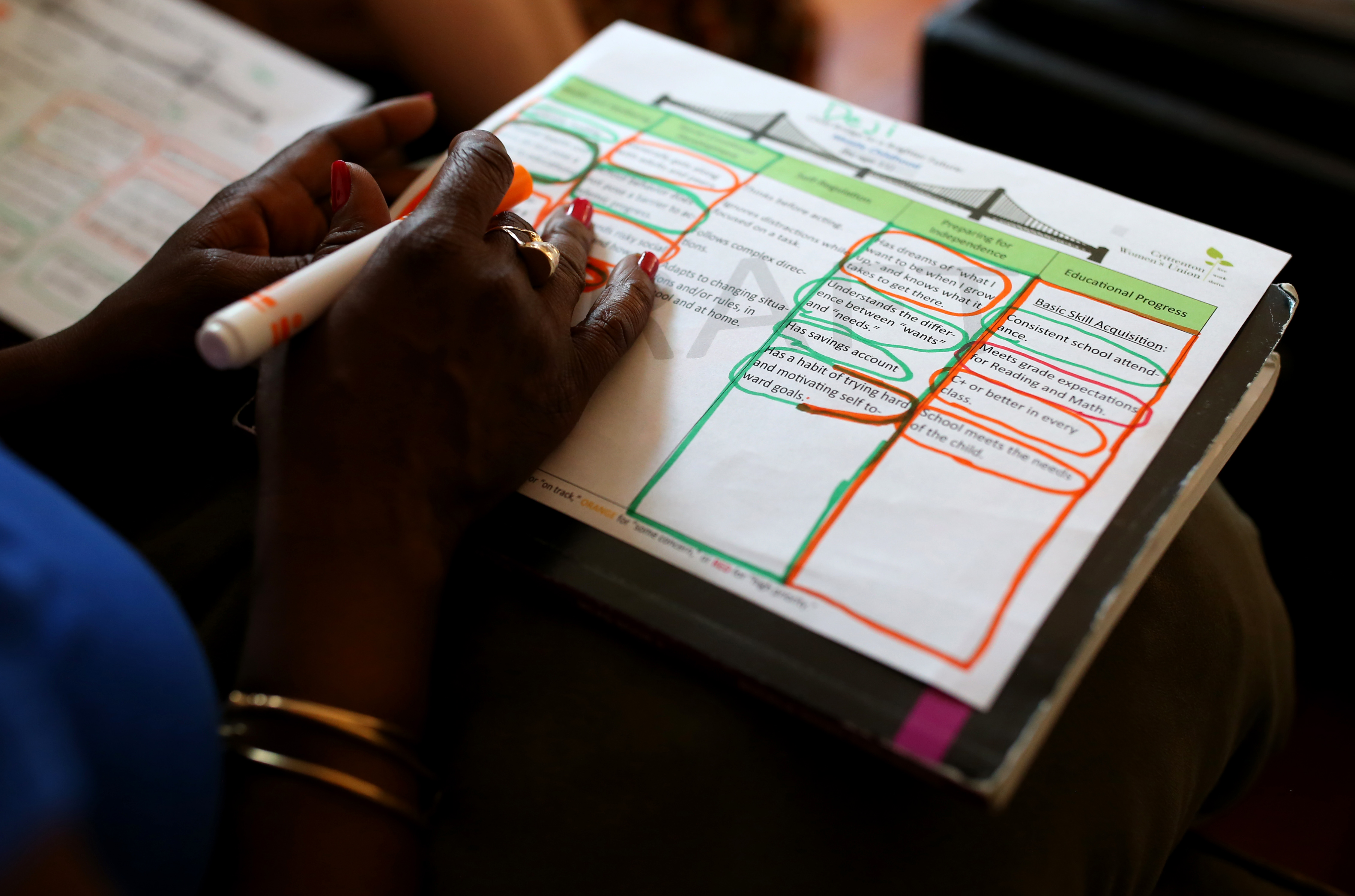 Ayoka Marchan looked over her daughter’s Bridge to a Brighter Future chart during a home visit.