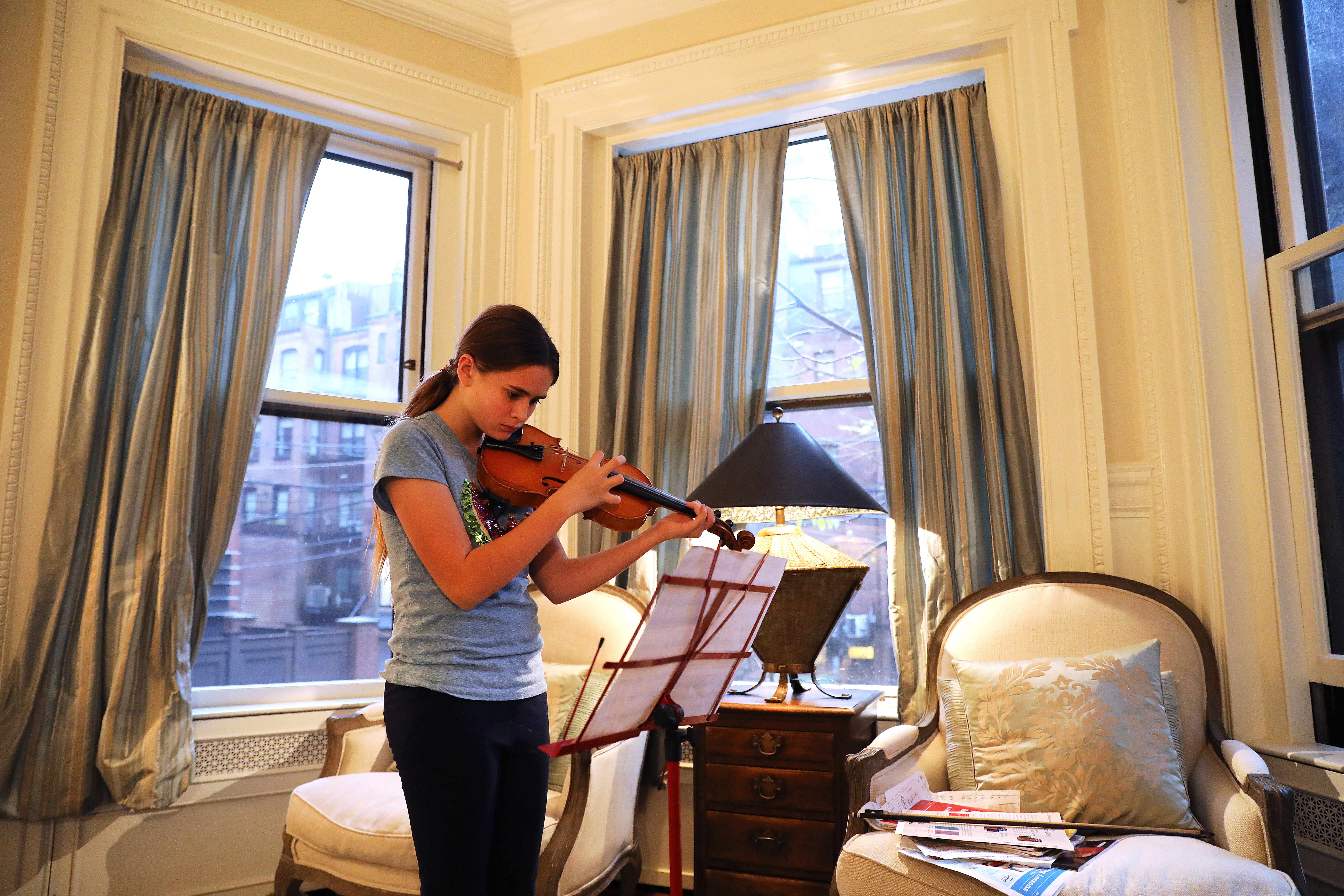Izzi practices violin in her Back Bay home.