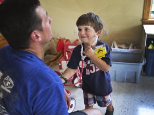 Toby, a 3-year-old at Camp Sunshine, played doctor with a Navy SEAL.